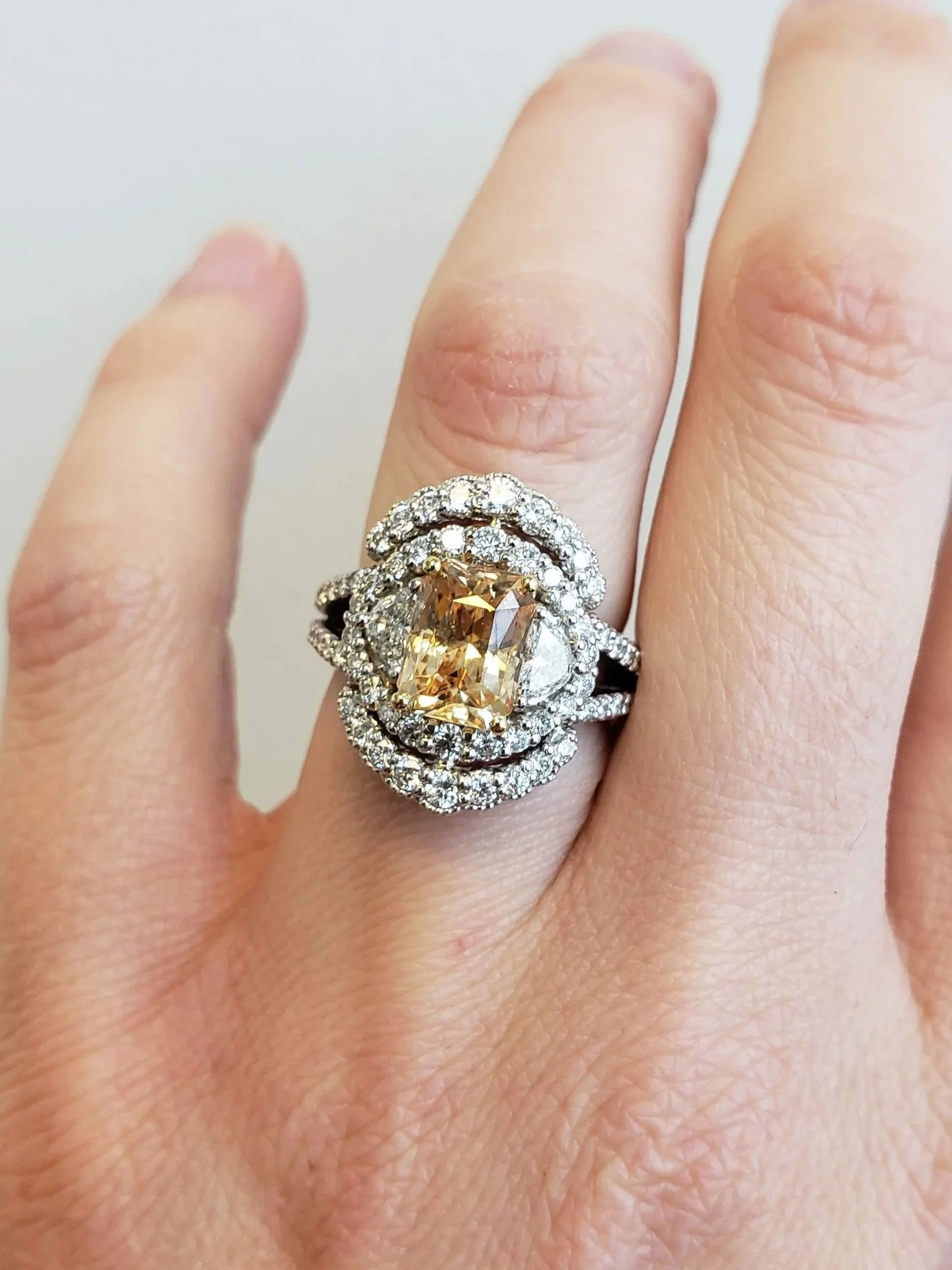 Padparadscha sapphire set into 19K white gold doubel halo split shank engagement ring