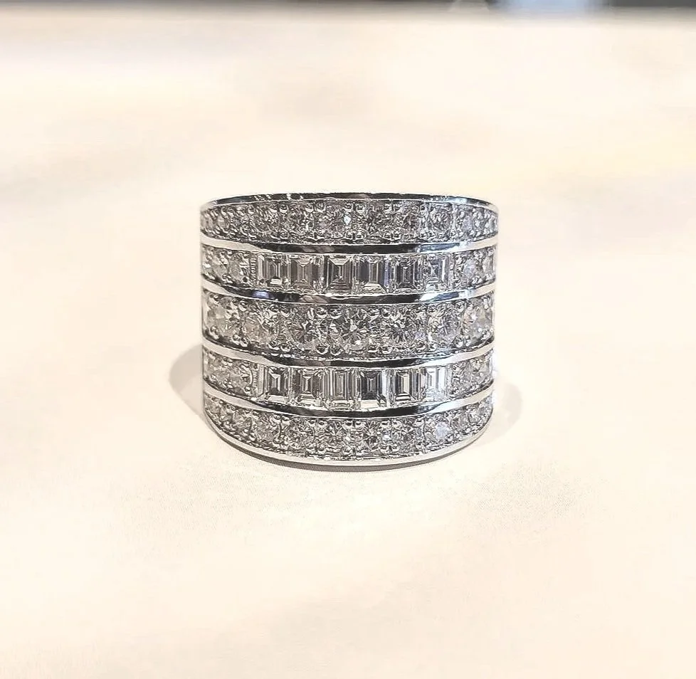 Custom redesign project using clients existing diamonds. Mixture of cuts set in channel and prong settings, 19K white gold.