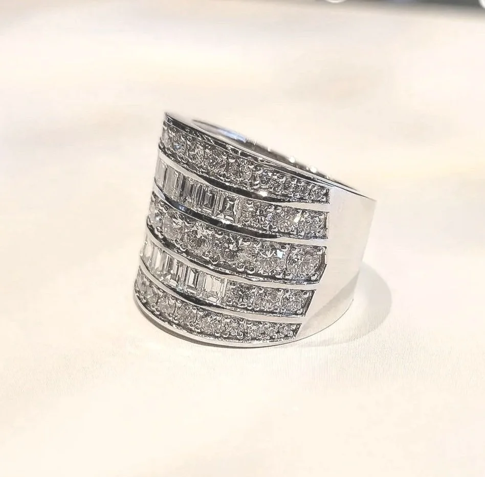 Custom redesign project using clients existing diamonds. Mixture of cuts set in channel and prong settings, 19K white gold.