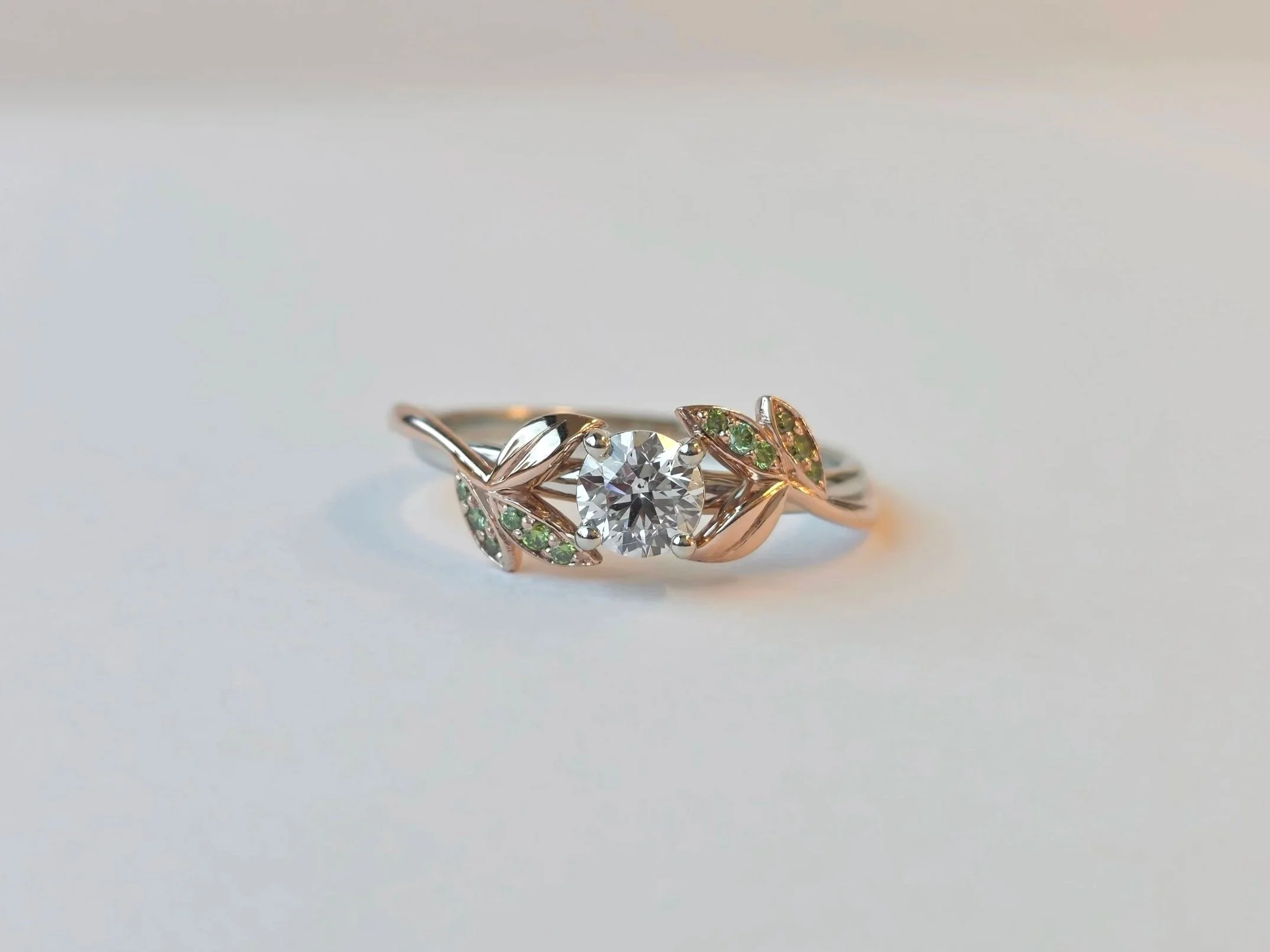Nature inspired engagement ring set with natural diamond mined from Diavik, and green diamond accent diamonds, in rose and white gold.
[engagement]