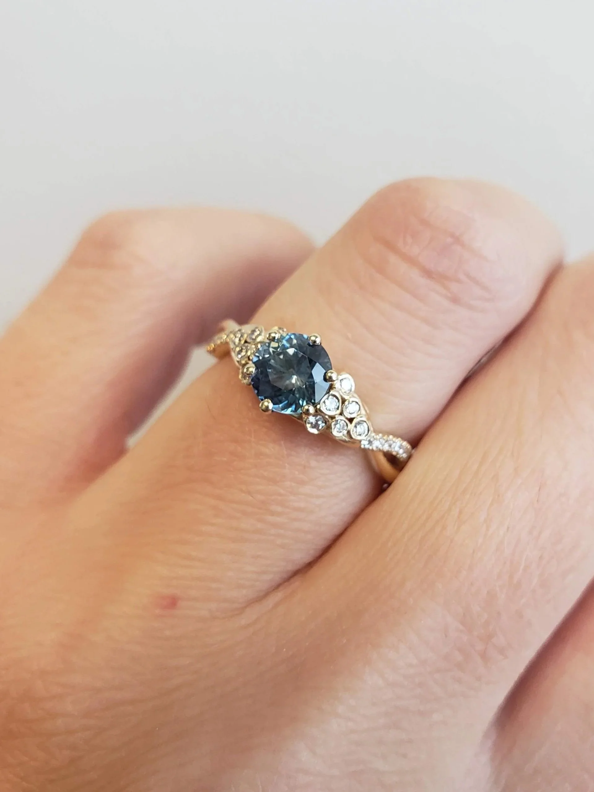 Blue Montana Sapphire Engagement Ring with Bezel set accents in yellow gold