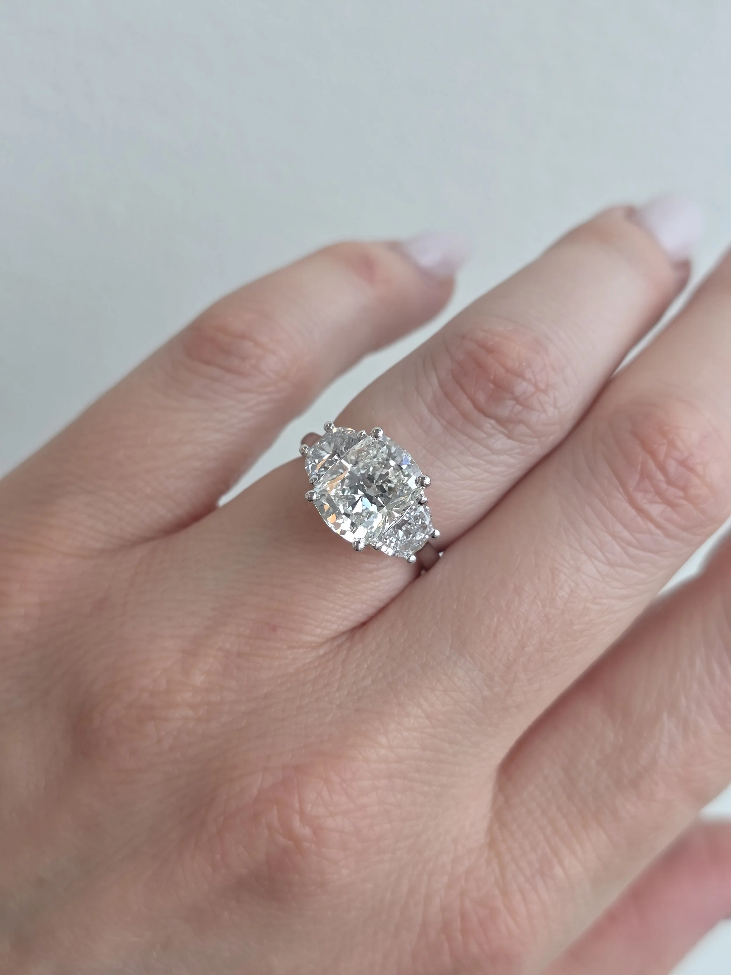 Custom elongated cushion three stone engagement ring with half moon accents
[engagement]
