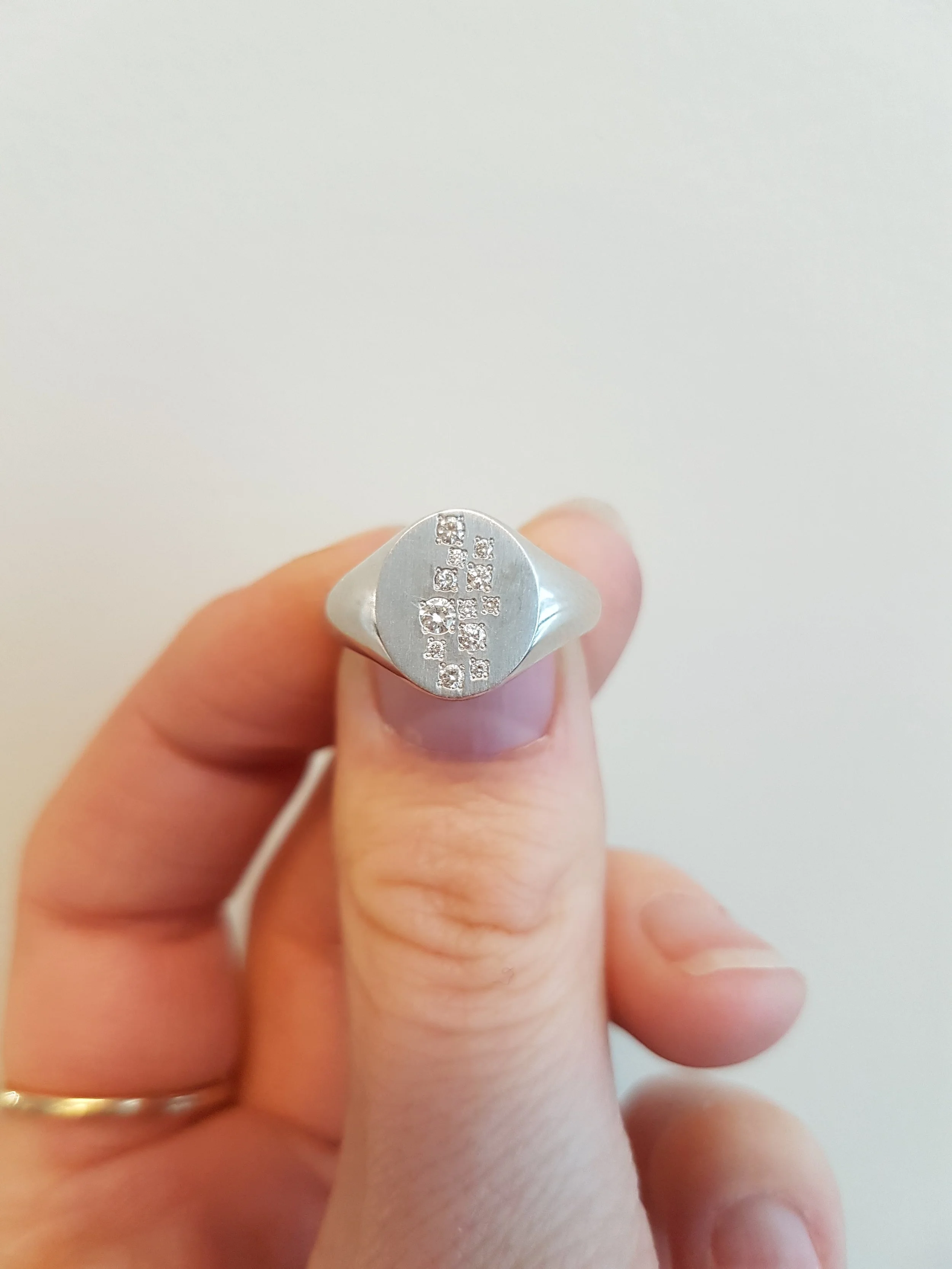 Scattered diamonds set into white gold signet ring