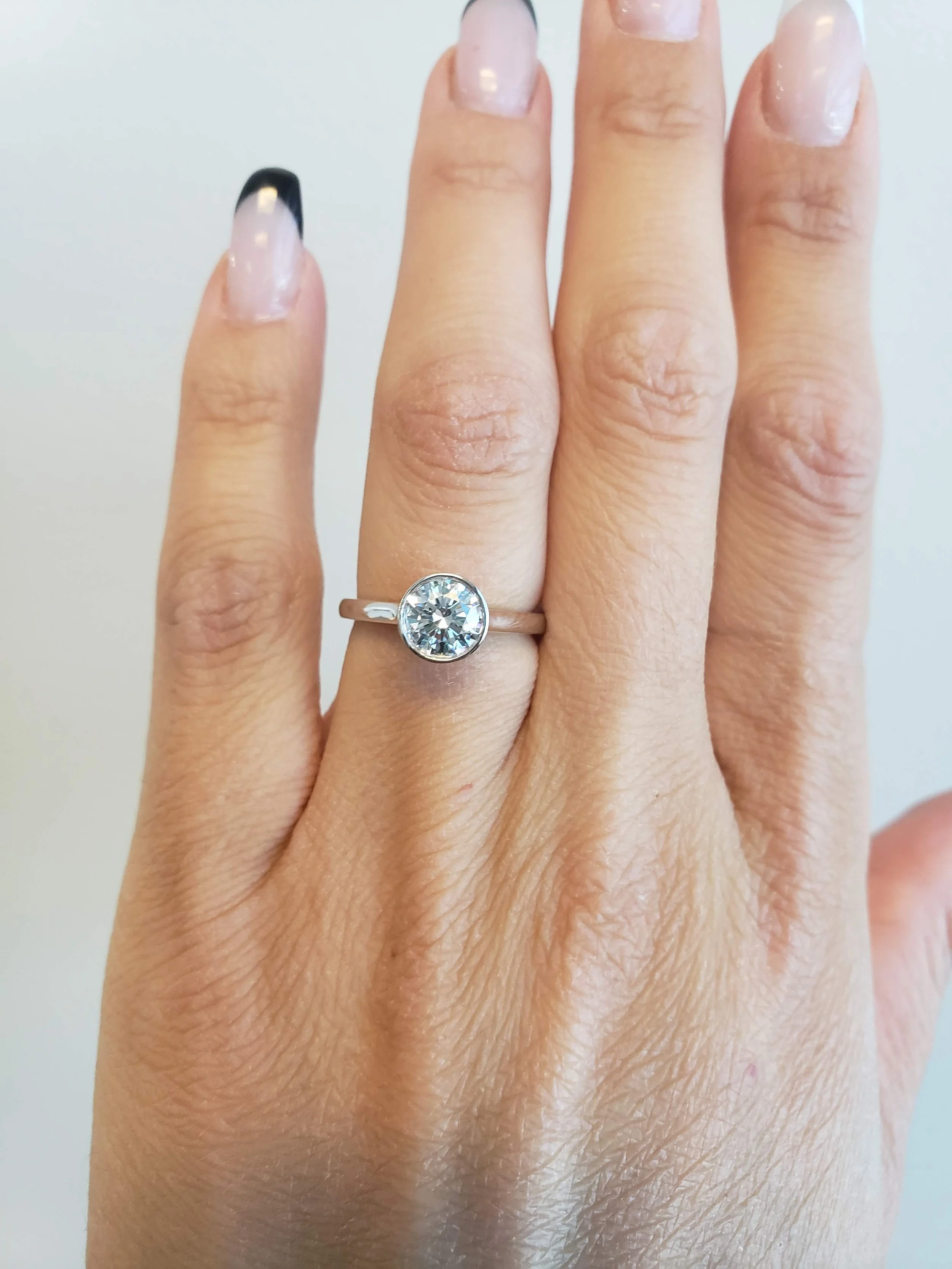 Round brilliant cut bezel set engagement ring in platinum