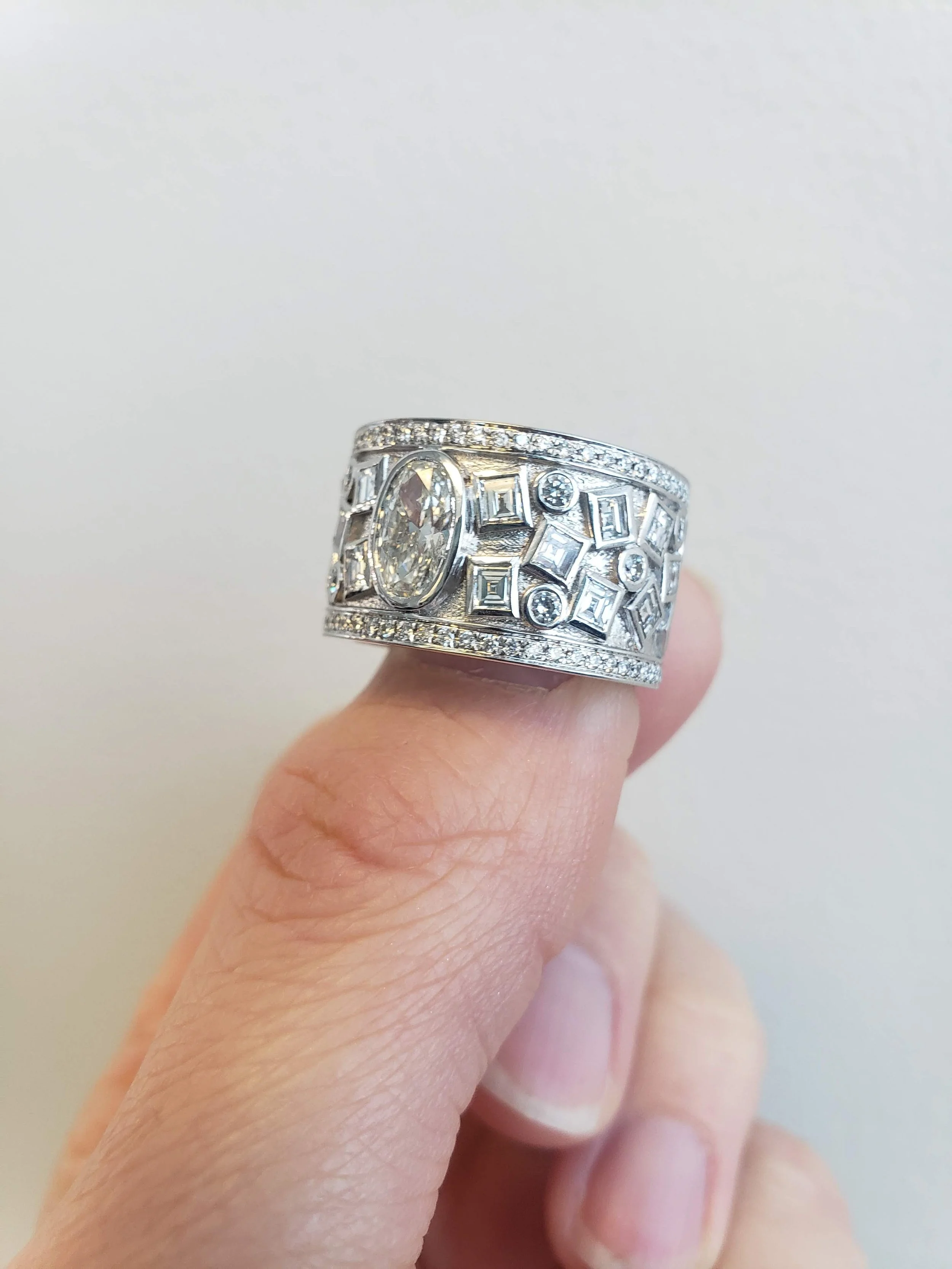 Custom ring with bezel set centre and prong and bezel set accents