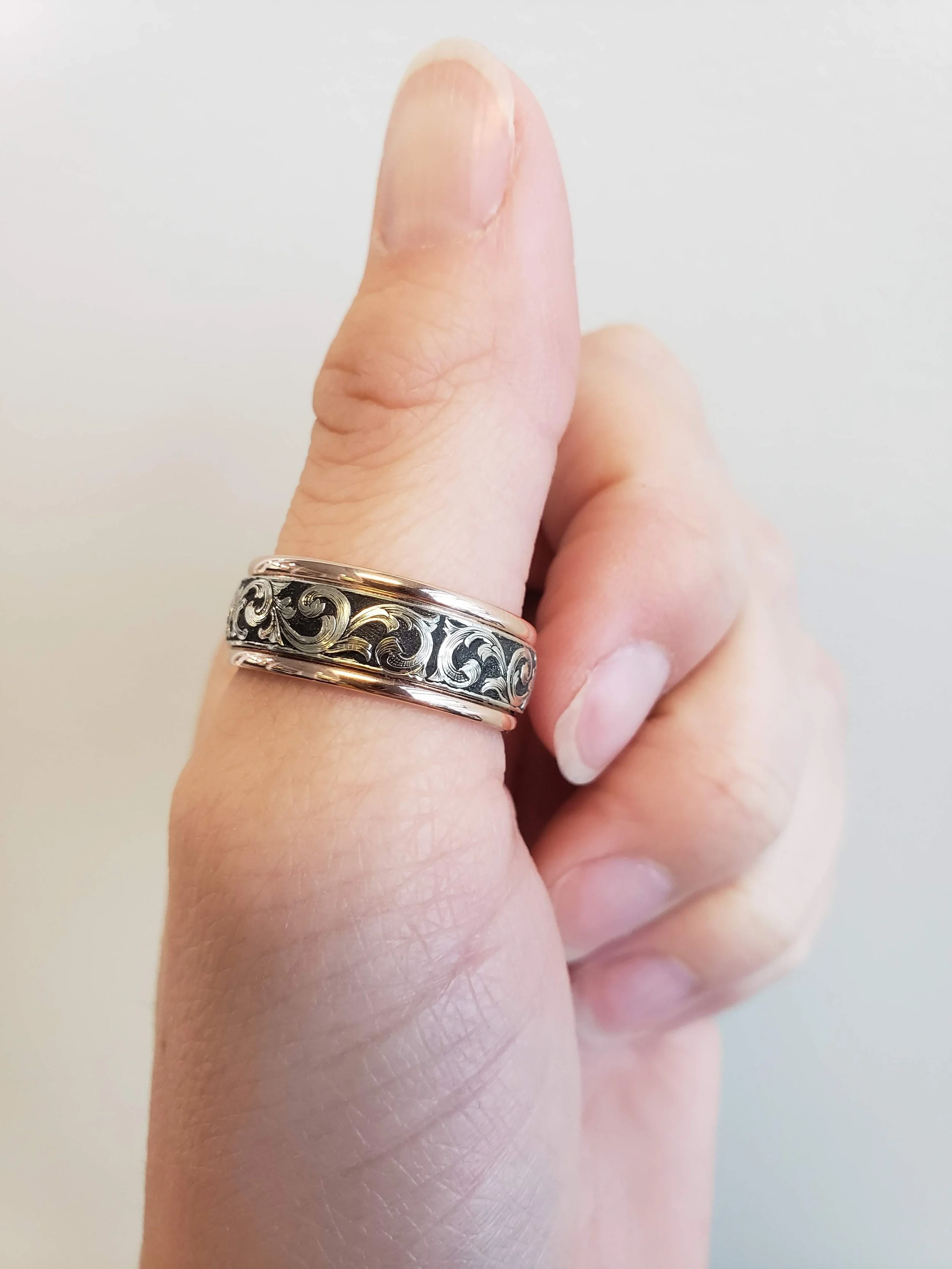Custom made hand engraved wedding band with black inlay. Hand engraved in Calgary.