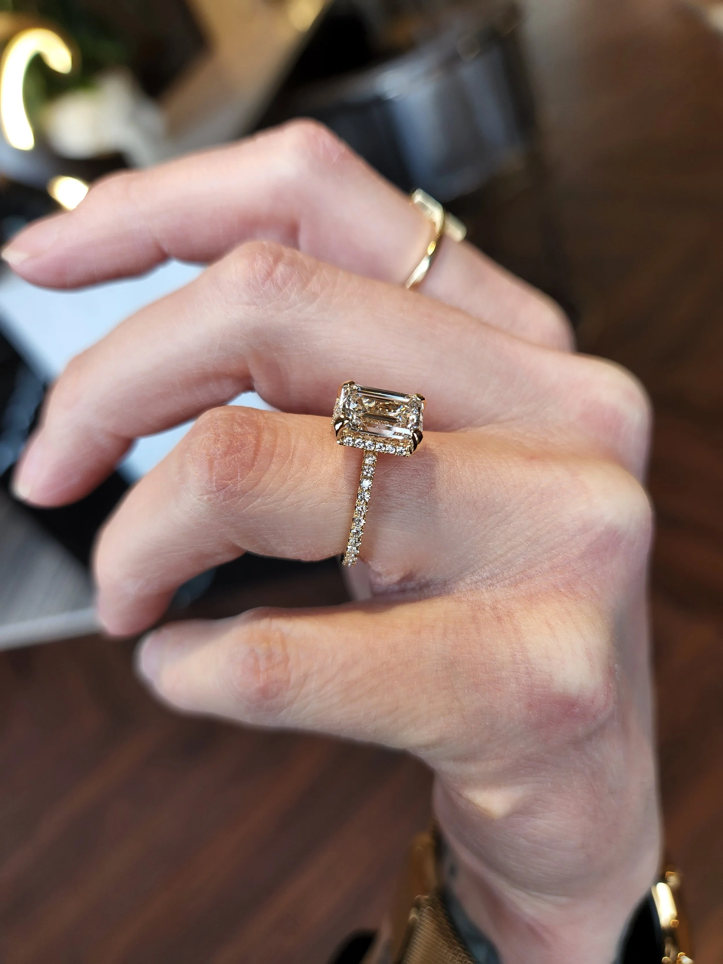 Emerald cut diamond engagement ring with drop halo set in 14K yellow gold
