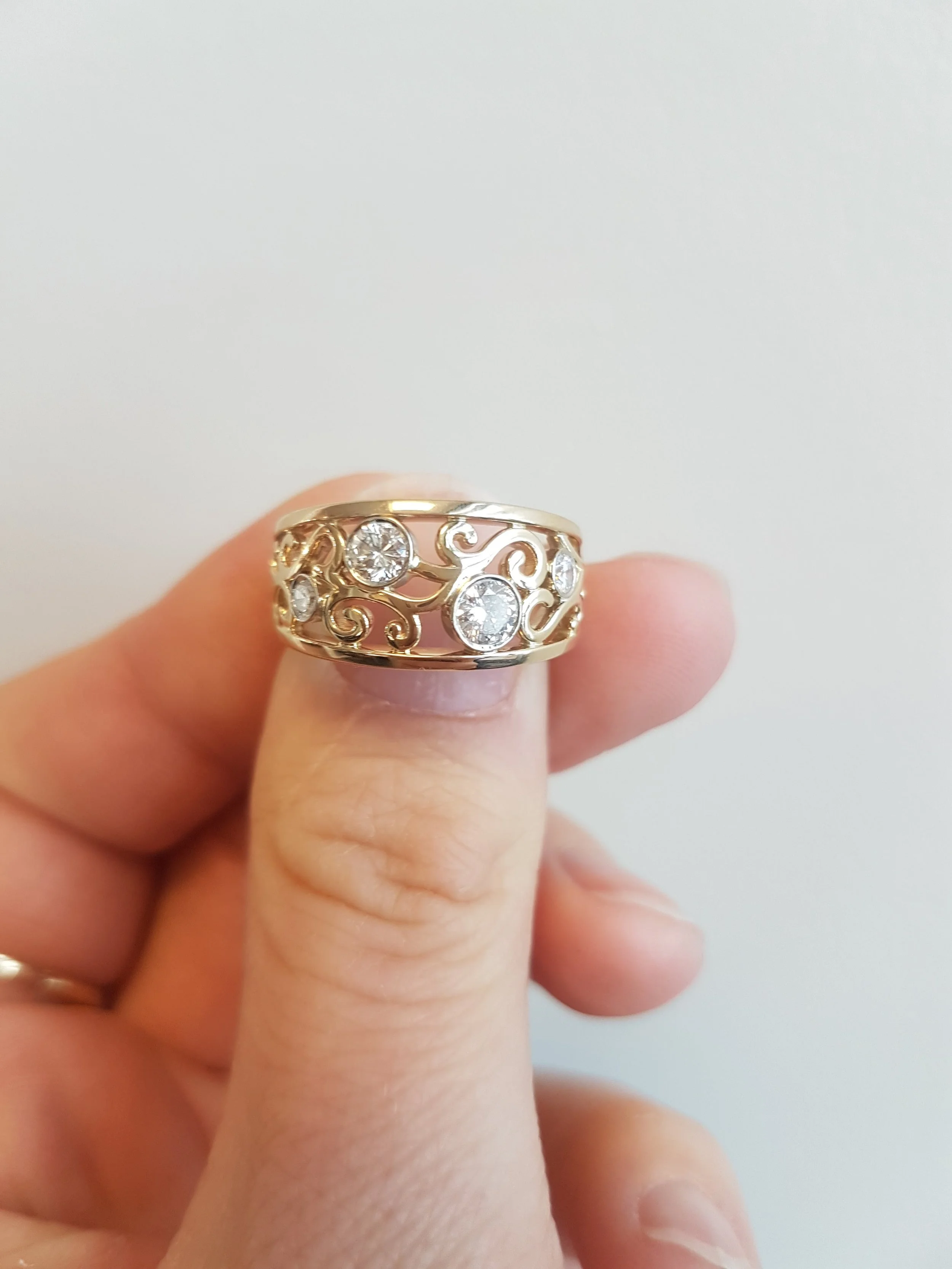 Custom 14K/W yellow gold scrollwork ring with bezel set diamonds