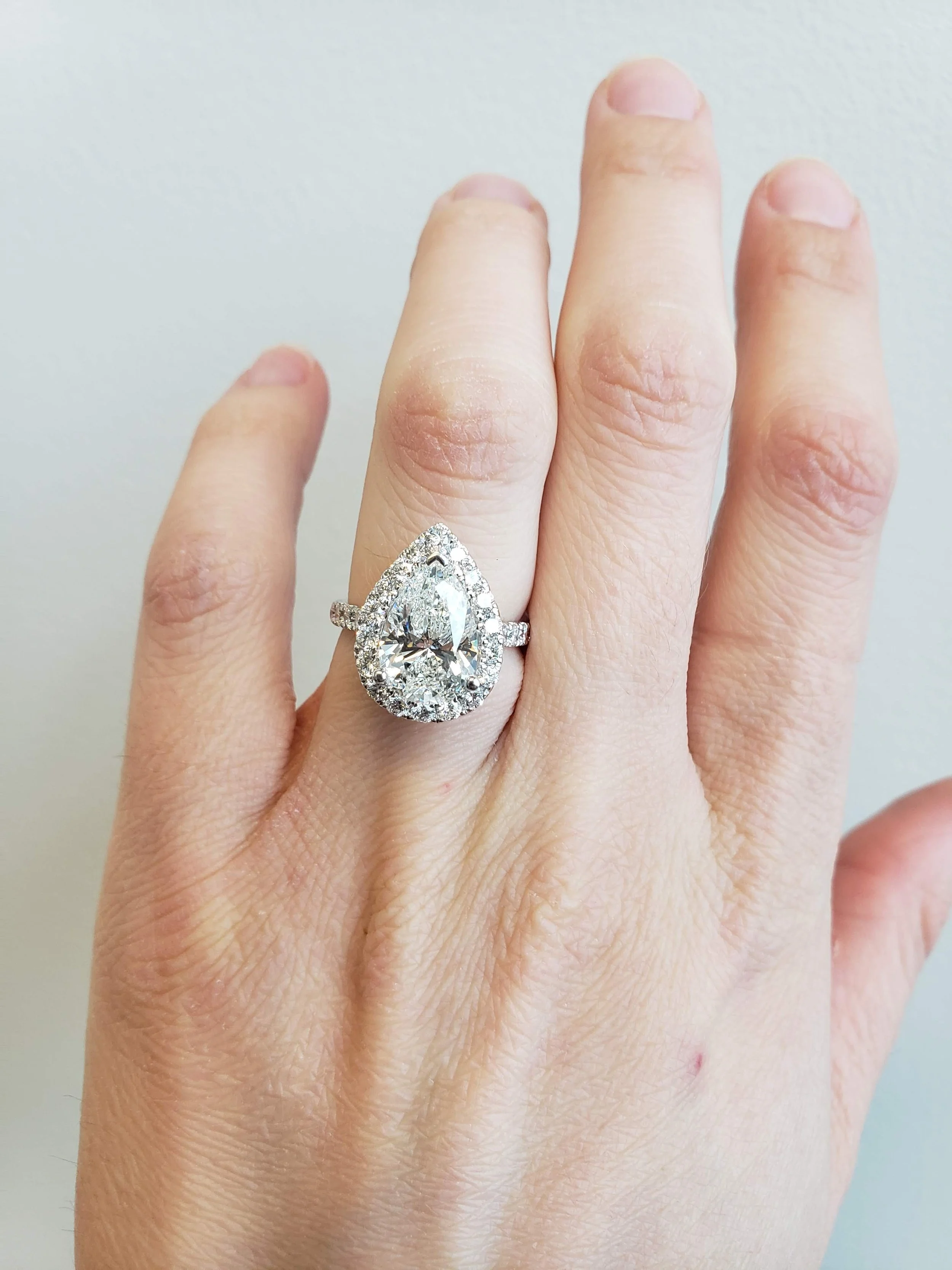 Pear shaped diamond halo engagement ring