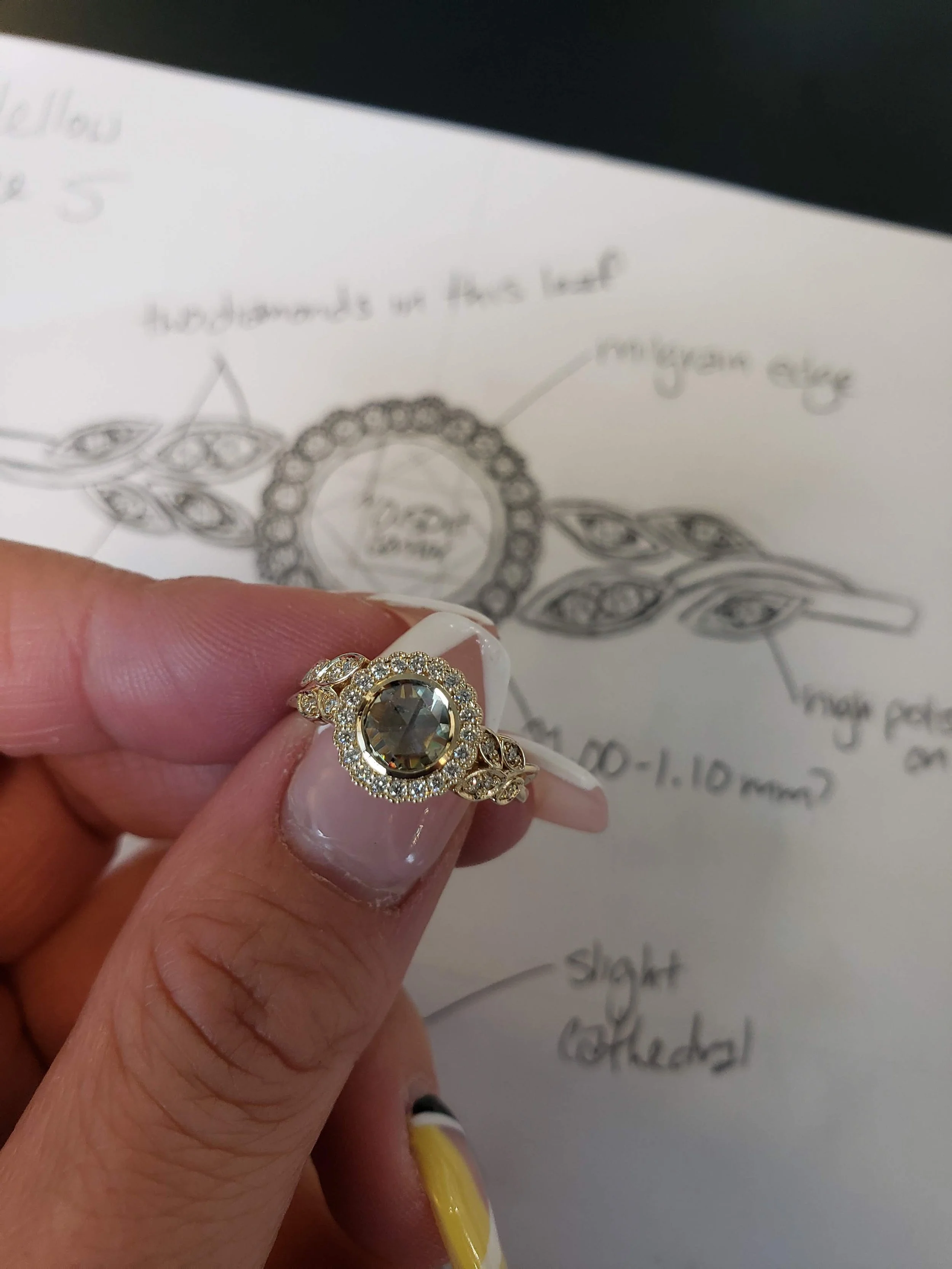 Custom floral motif engagement ring with rose cut salt and pepper centre set into milgrain bezel, with prong set diamond accents in yellow gold