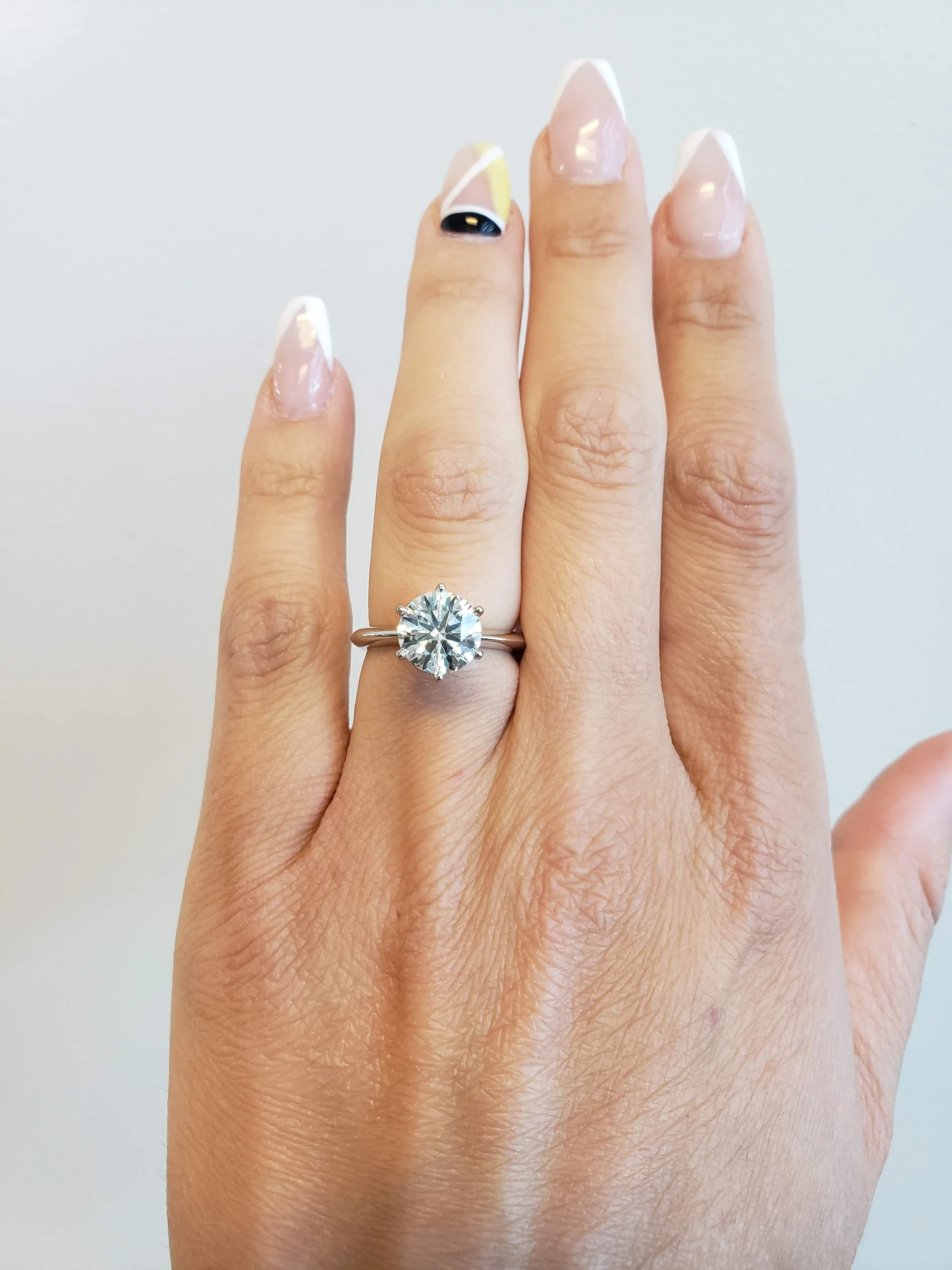 Six prong set round brilliant cut engagement ring in knife edge band