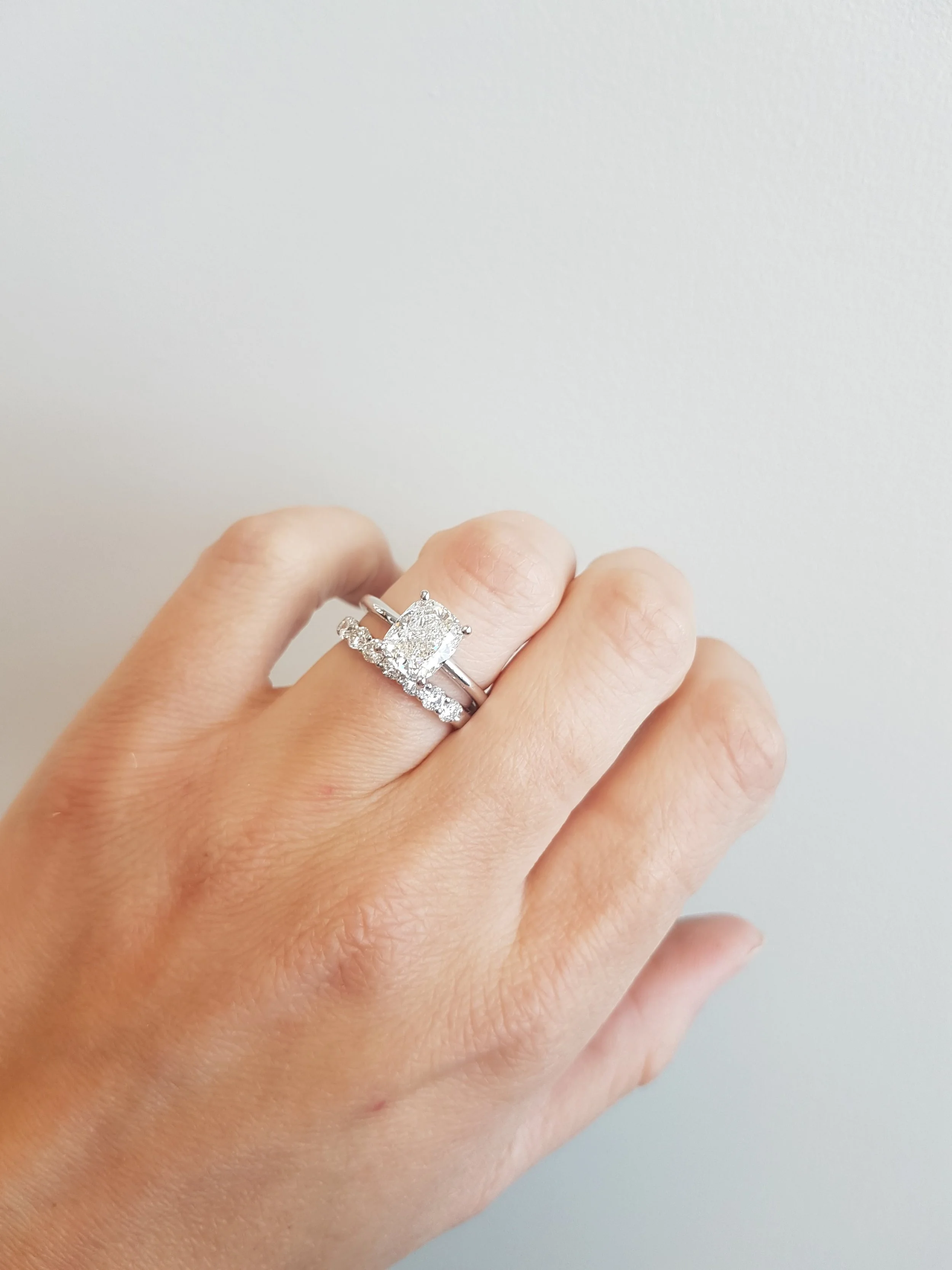 Cusion cut diamond engagement ring with shared prong diamond wedding band