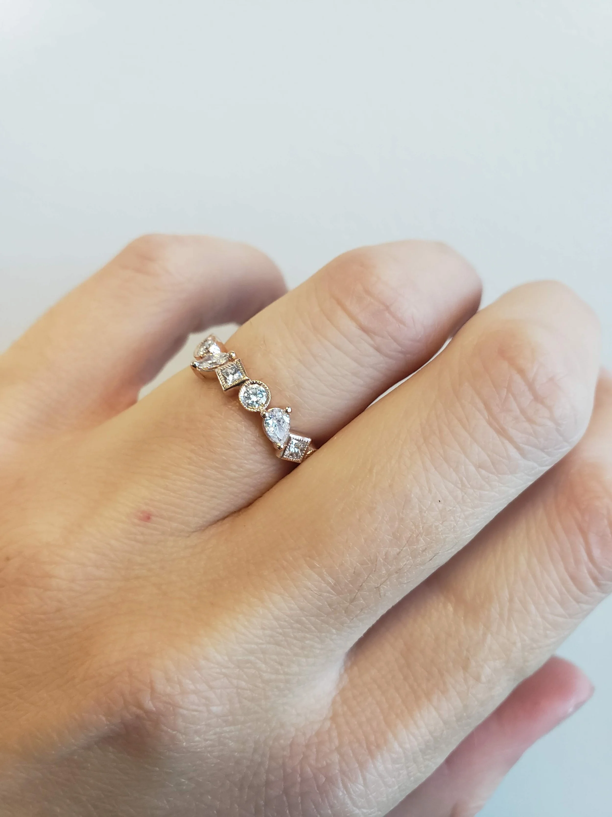 Mixed shape diamond band in rose gold with mixture of bezel and prong settings