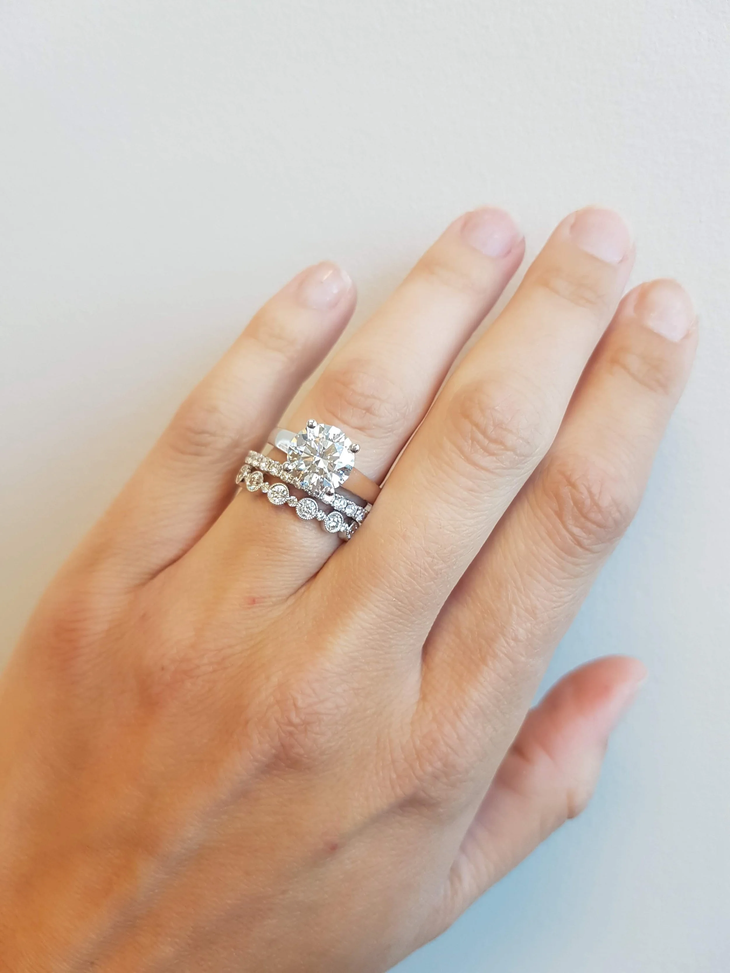 Round brilliant cut diamond engagment ring with micro pave set diamond band and bezel set diamond wedding band