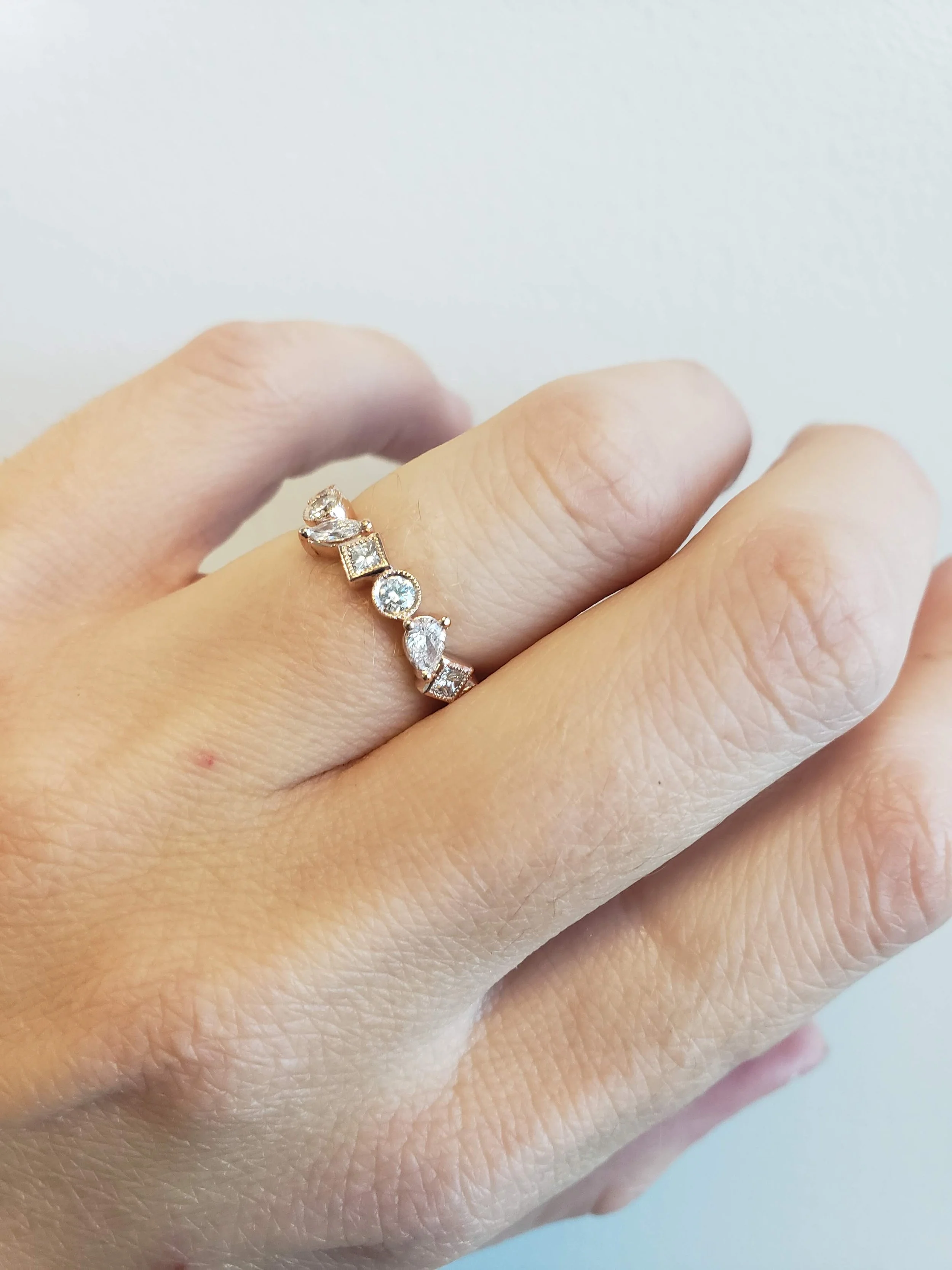 Mixed shape diamond band in rose gold with mixture of bezel and prong settings