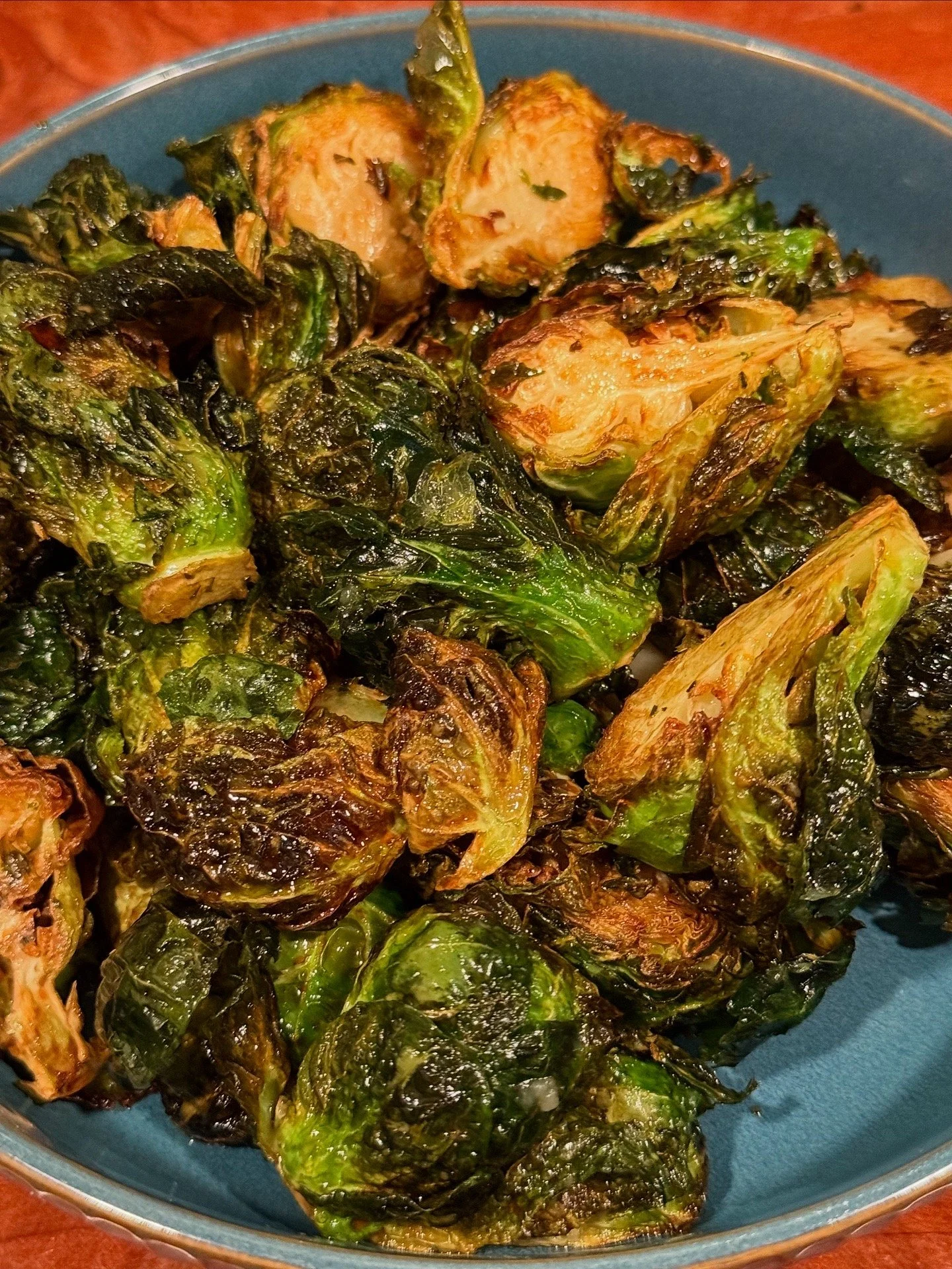 Roasted Brussels sprouts on a blue plate.