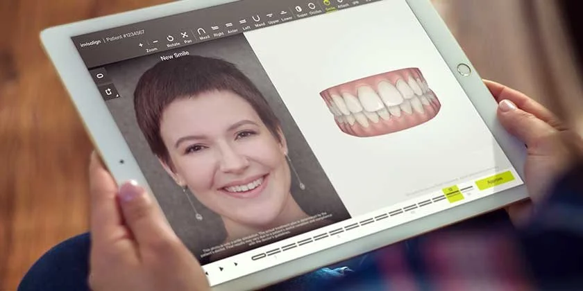 Person viewing a tablet displaying a digital smile makeover, including a smile image and a 3D model of teeth.