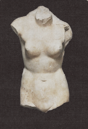 Ancient marble sculpture of a female torso on display.