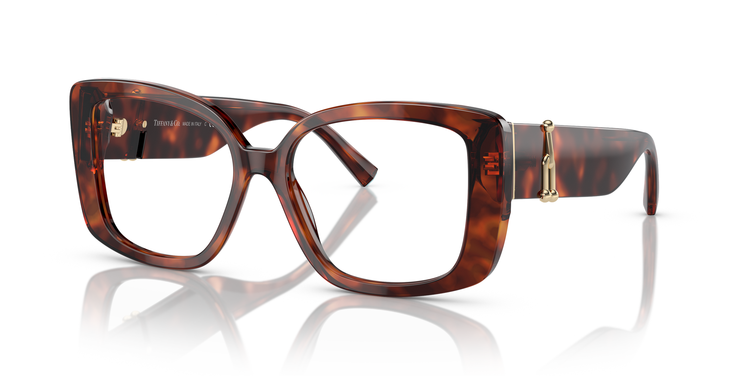 A pair of tortoiseshell Tiffany designer eyeglasses with gold accents, positioned on a reflective white surface.