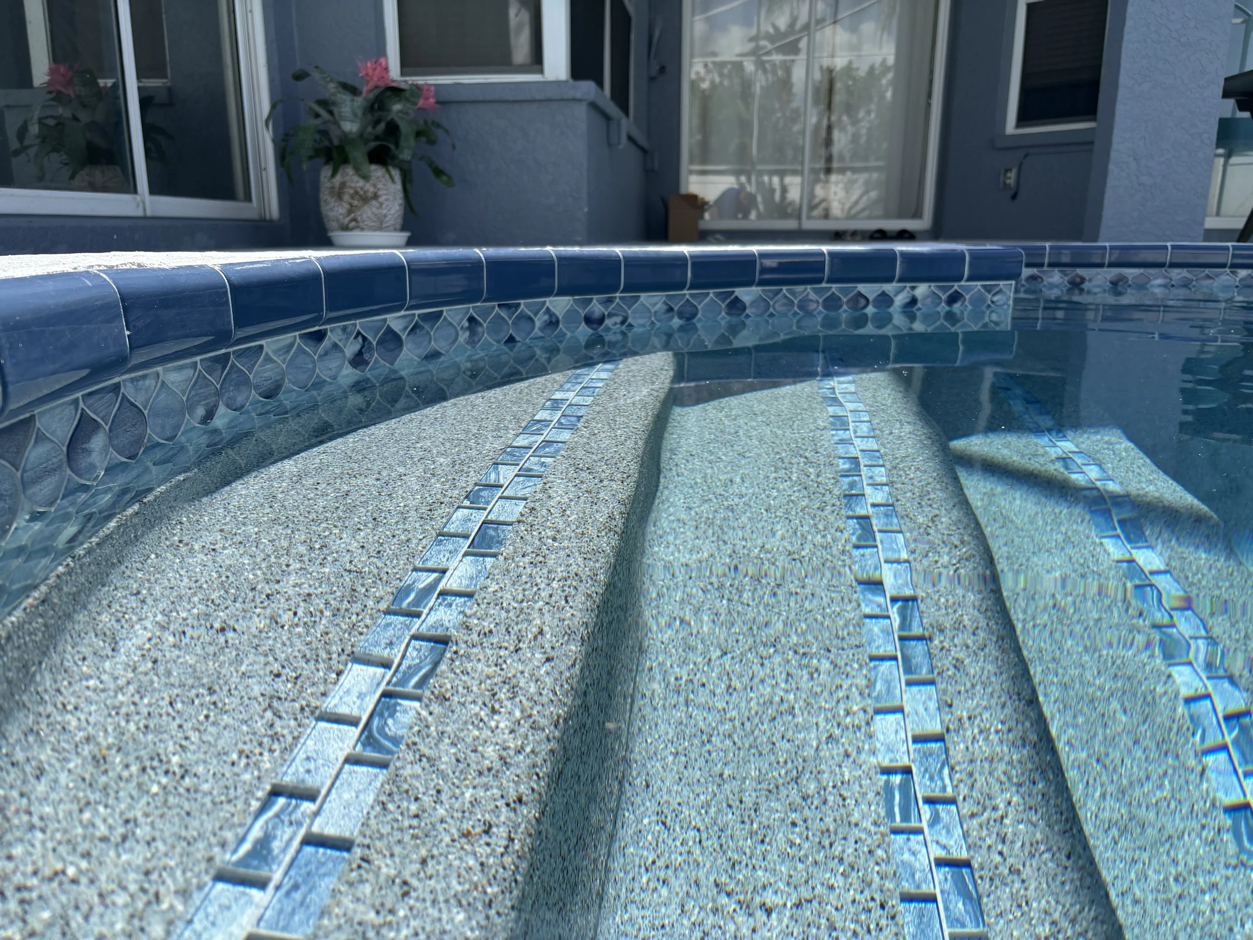 Close up of a fully renovated pool, clear water, new tile and finish