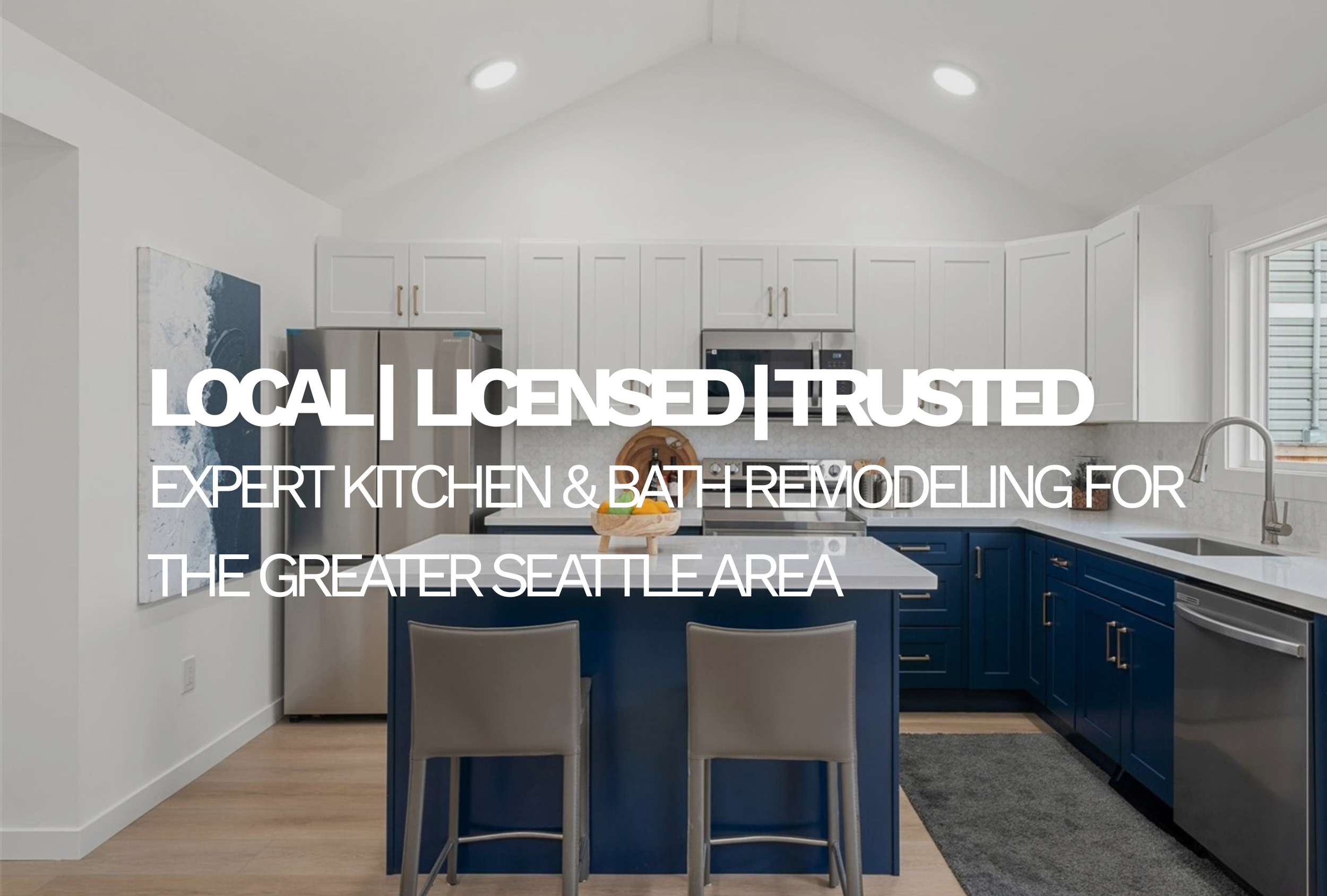 Modern kitchen with white upper cabinets, navy lower cabinets, stainless steel appliances, a kitchen island with two chairs, and a window with natural light.