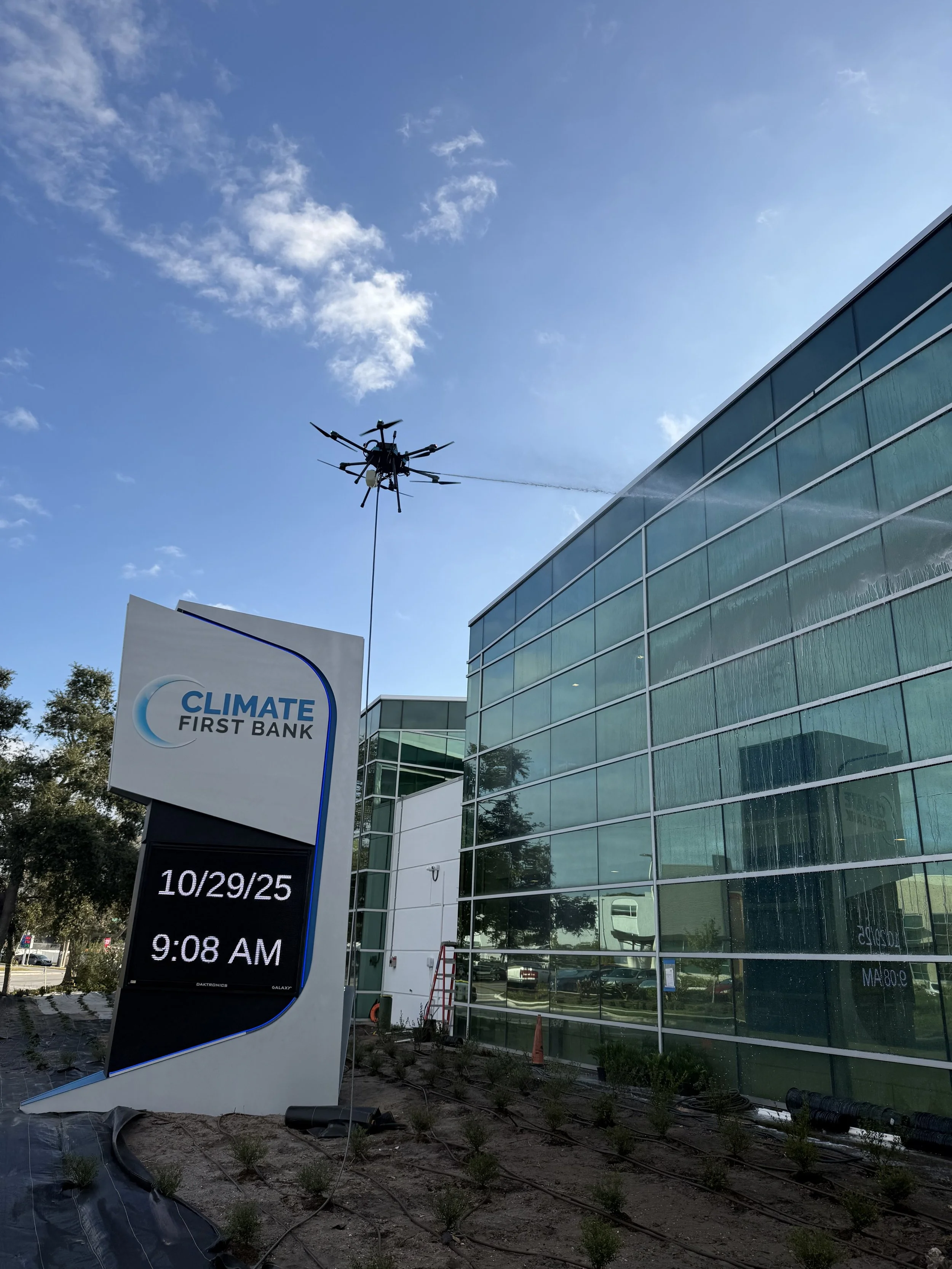 Climate first bank being cleaned by a cleaning drone with cleaning solution spraying out of the drone
