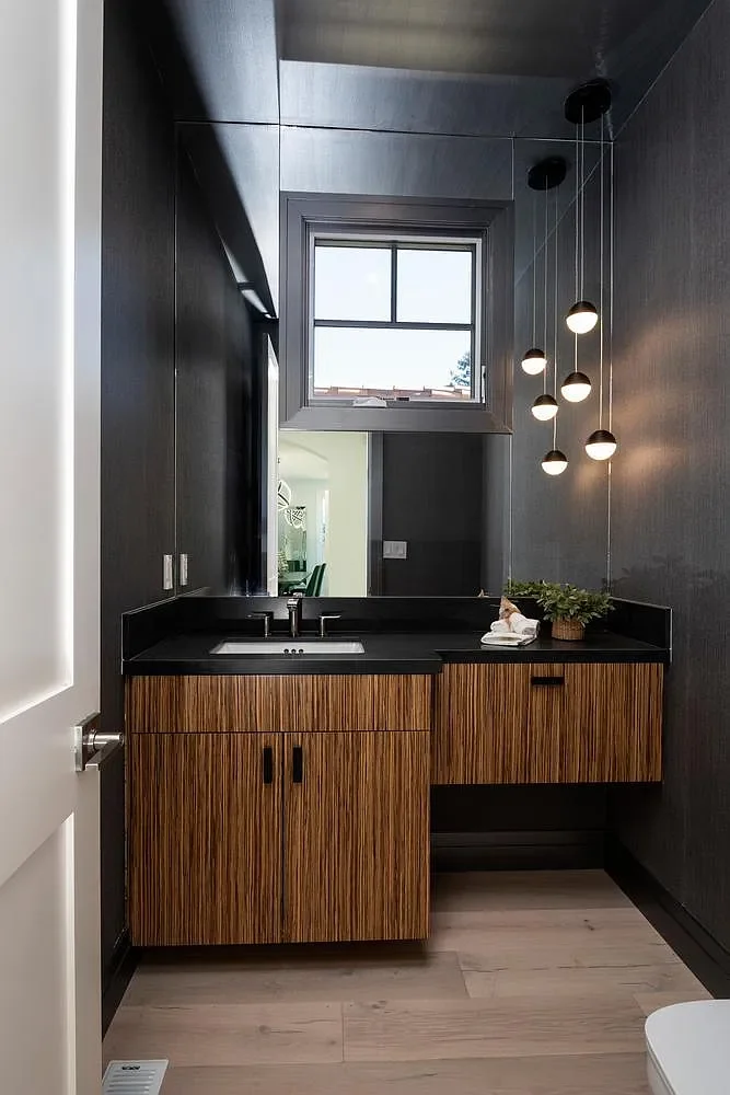 “A bold, masculine powder room — moody tones and sleek finishes create a sophisticated, sexy statement space.