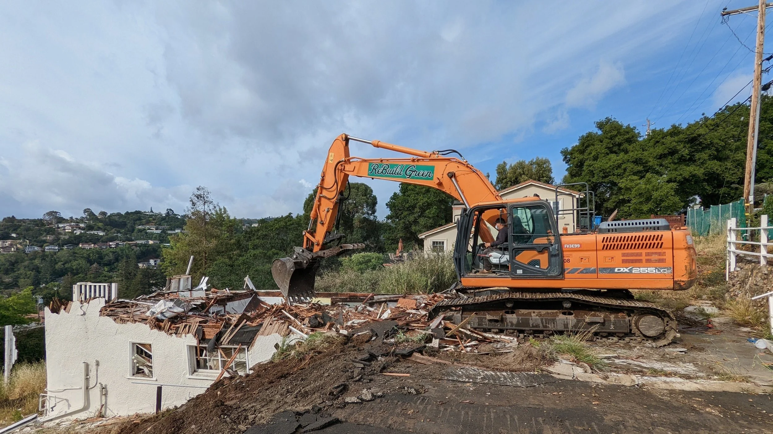 Careful demolition on a hillside lot—preparing the site for brand new homes designed to maximize the slope and views.