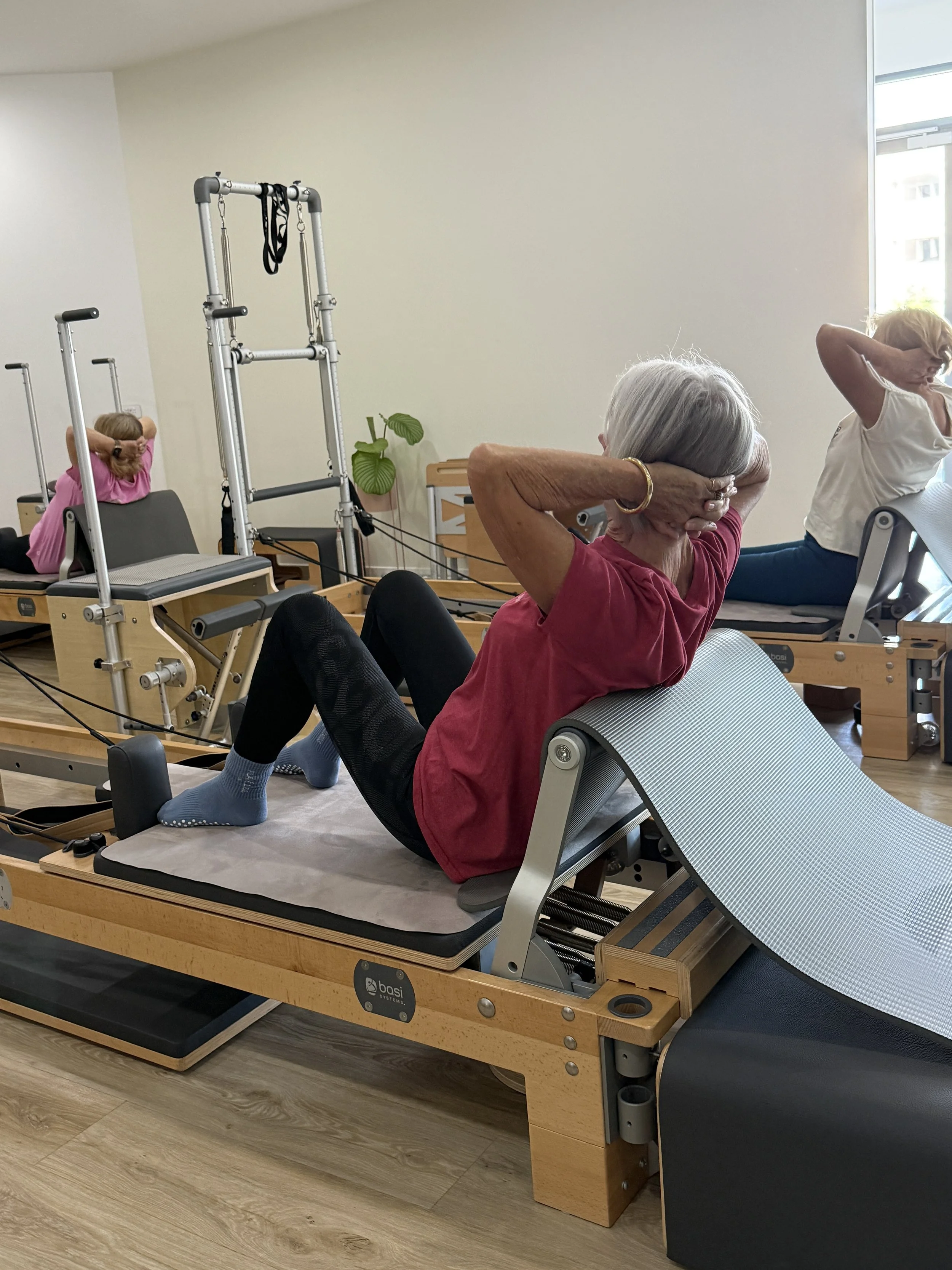 Living Well Back extension work over the reformer footbar, padded with a mat for comfort.
