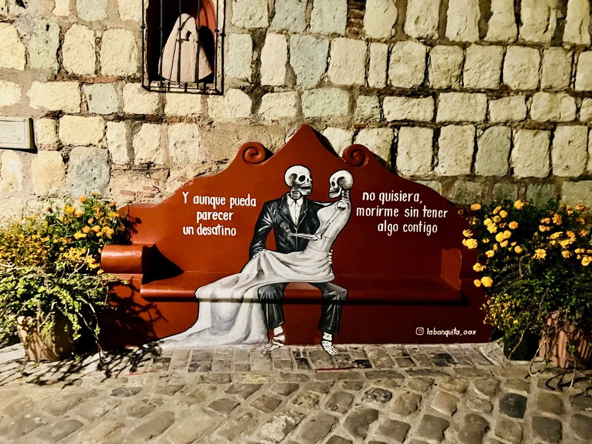 ornate bench in front of a stone wall