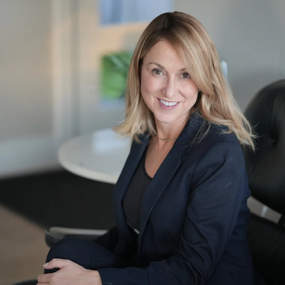 Shelley Perry seated in a modern office, smiling