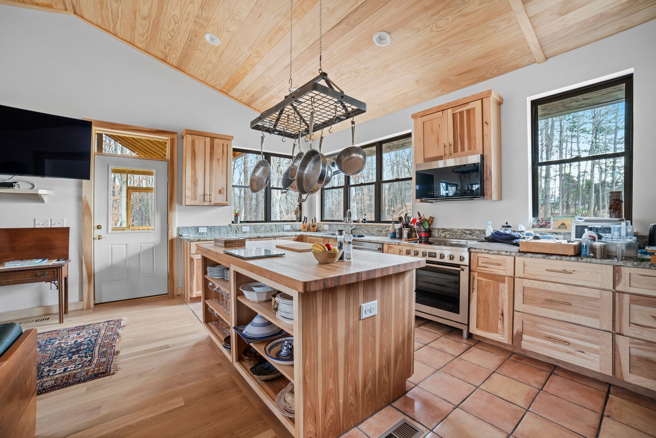 wooden kitchen remodel by roll construction with bright natural light from big windows and cutlery