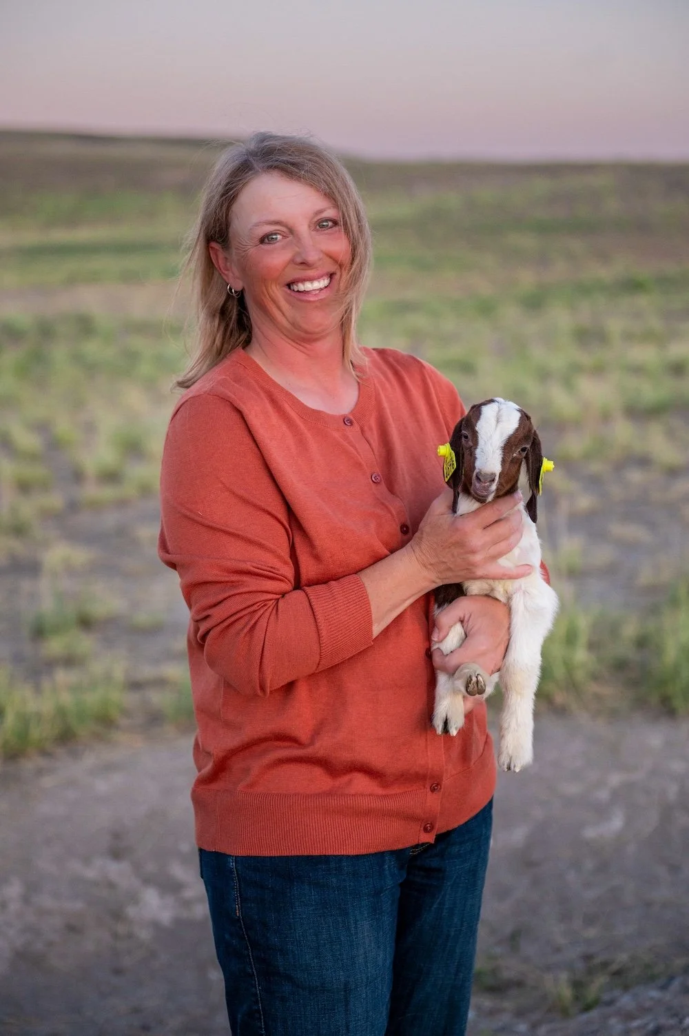 Millie Bradshaw holding goat kid at Dry Creek Pastures high desert ranch