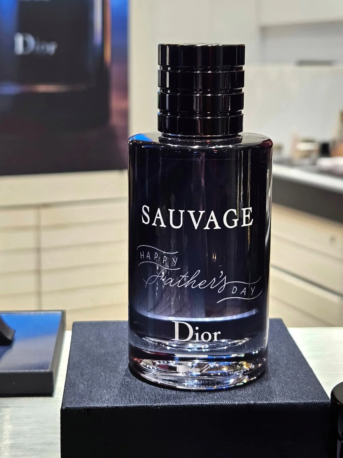 A black Christian Dior glass perfume bottle engraved with "HAPPY Father's DAY ".