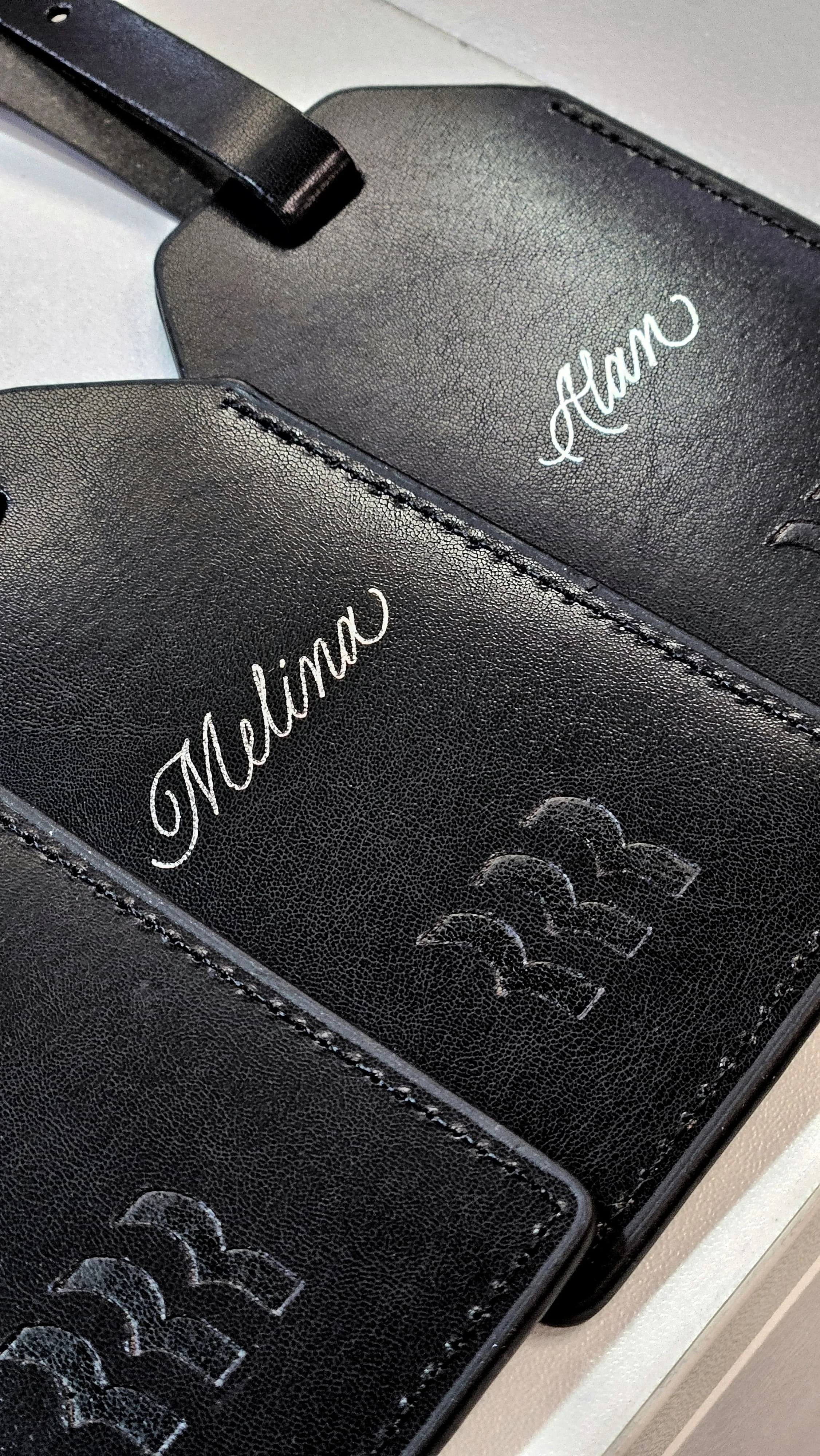 Two black leather luggage tags personalised with hot foiling technique
