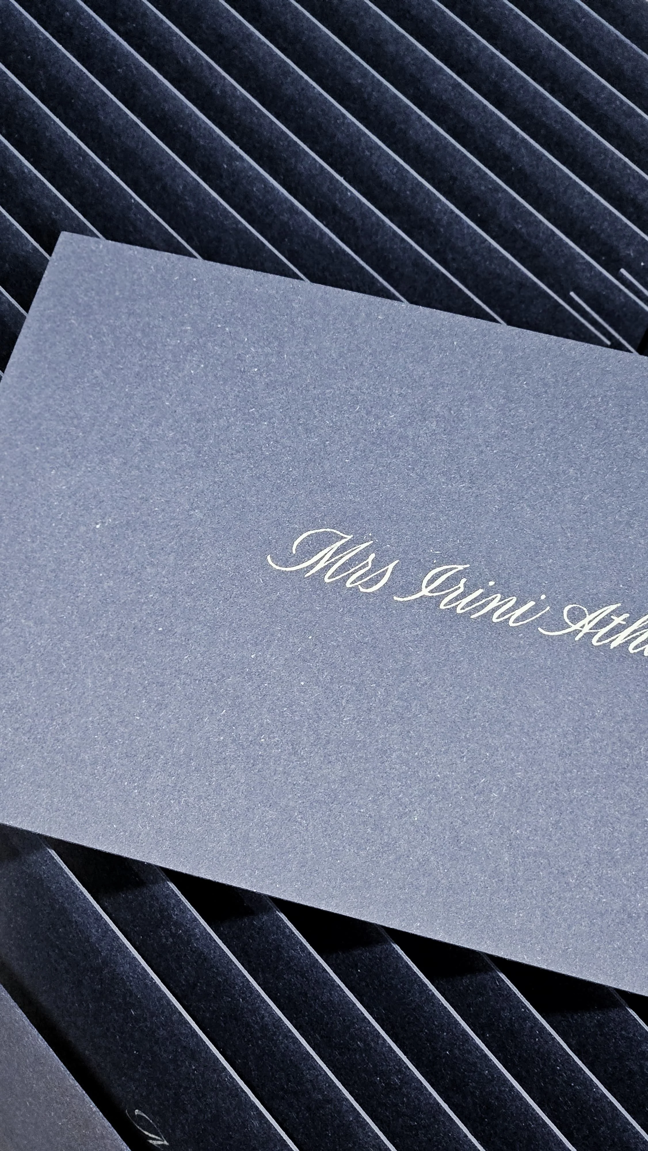 A close-up of gray envelopes with one addressed to Miss Ginni Ath