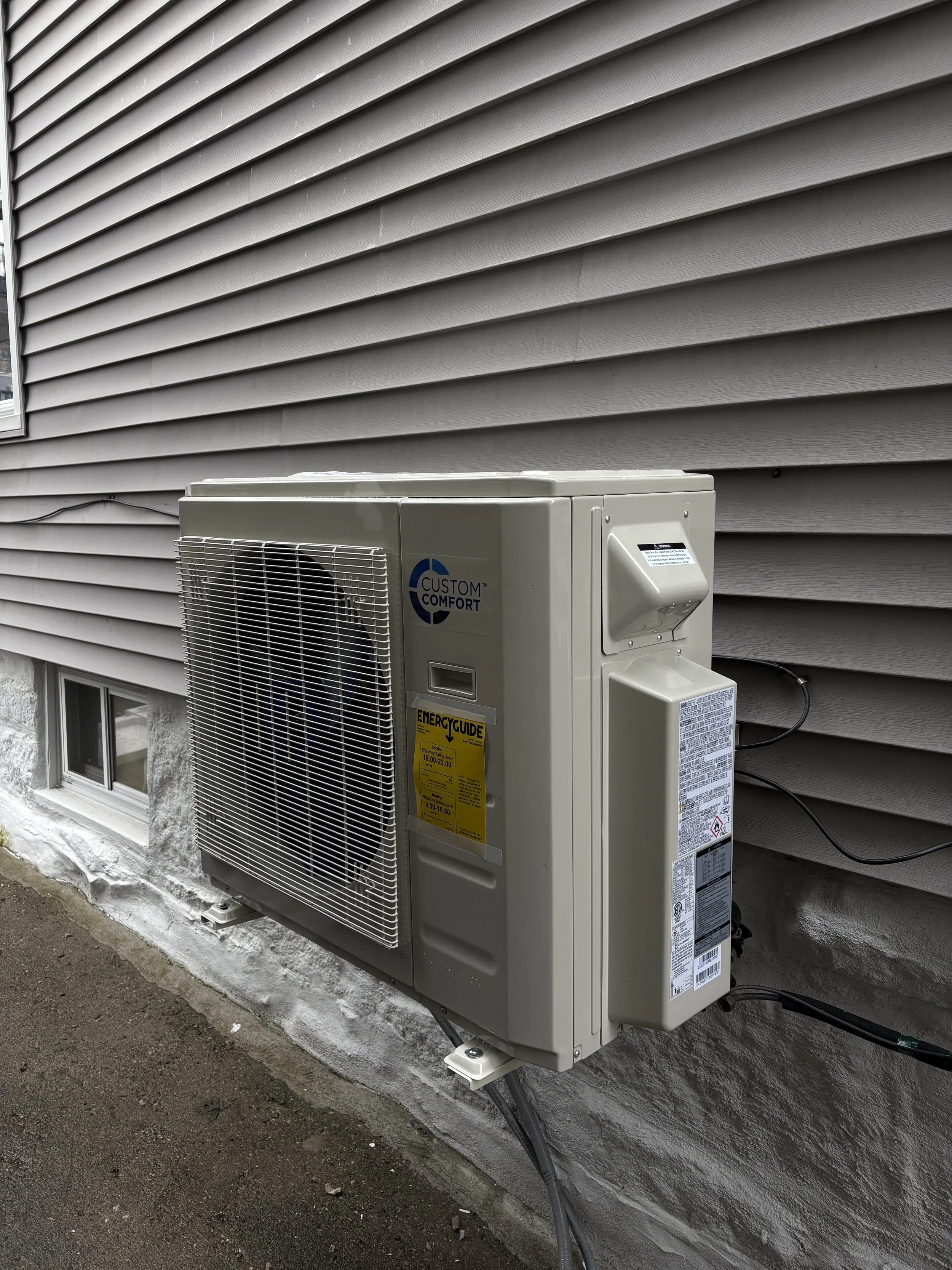 An outdoor air conditioning unit mounted on a building's exterior wall.