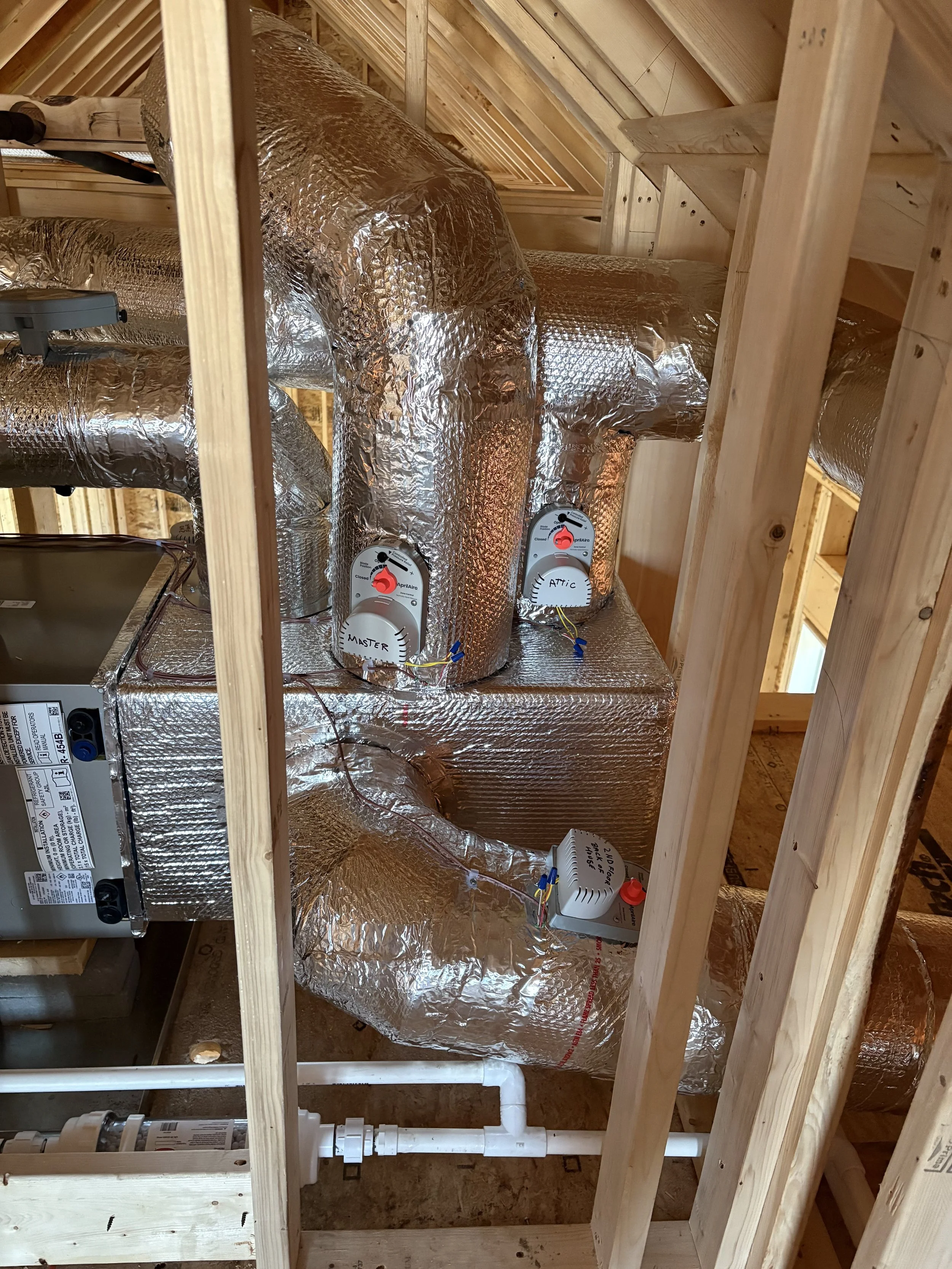Insulation ducts and controls for an HVAC system installation in an unfinished attic space.