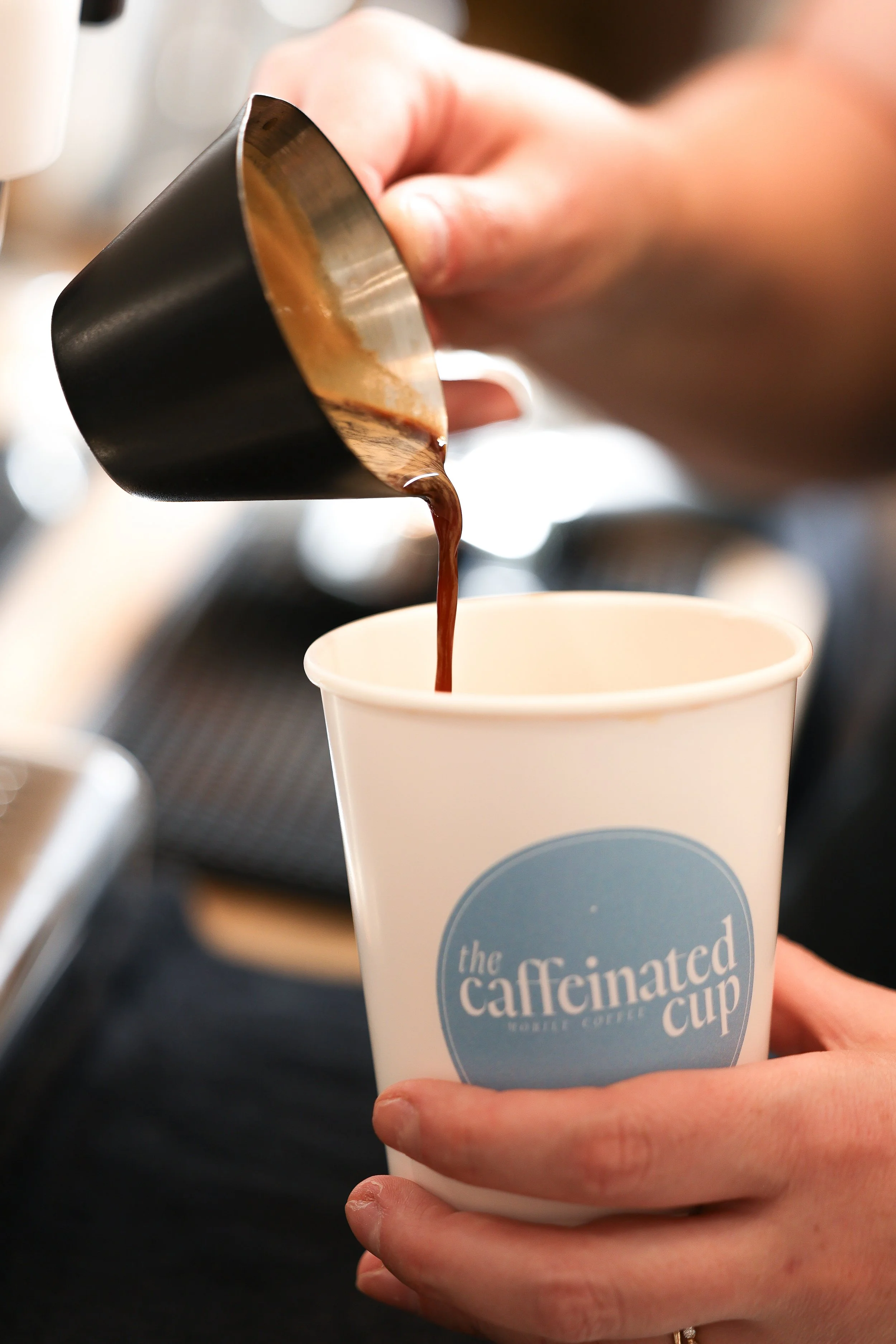 High quality espresso being poured into a custom Caffeinated Cup at a coffee catering event in South Jersey.