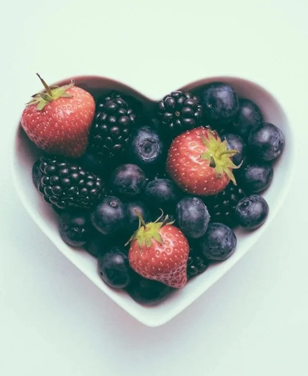 Heart shaped bowl of berries and strawberries