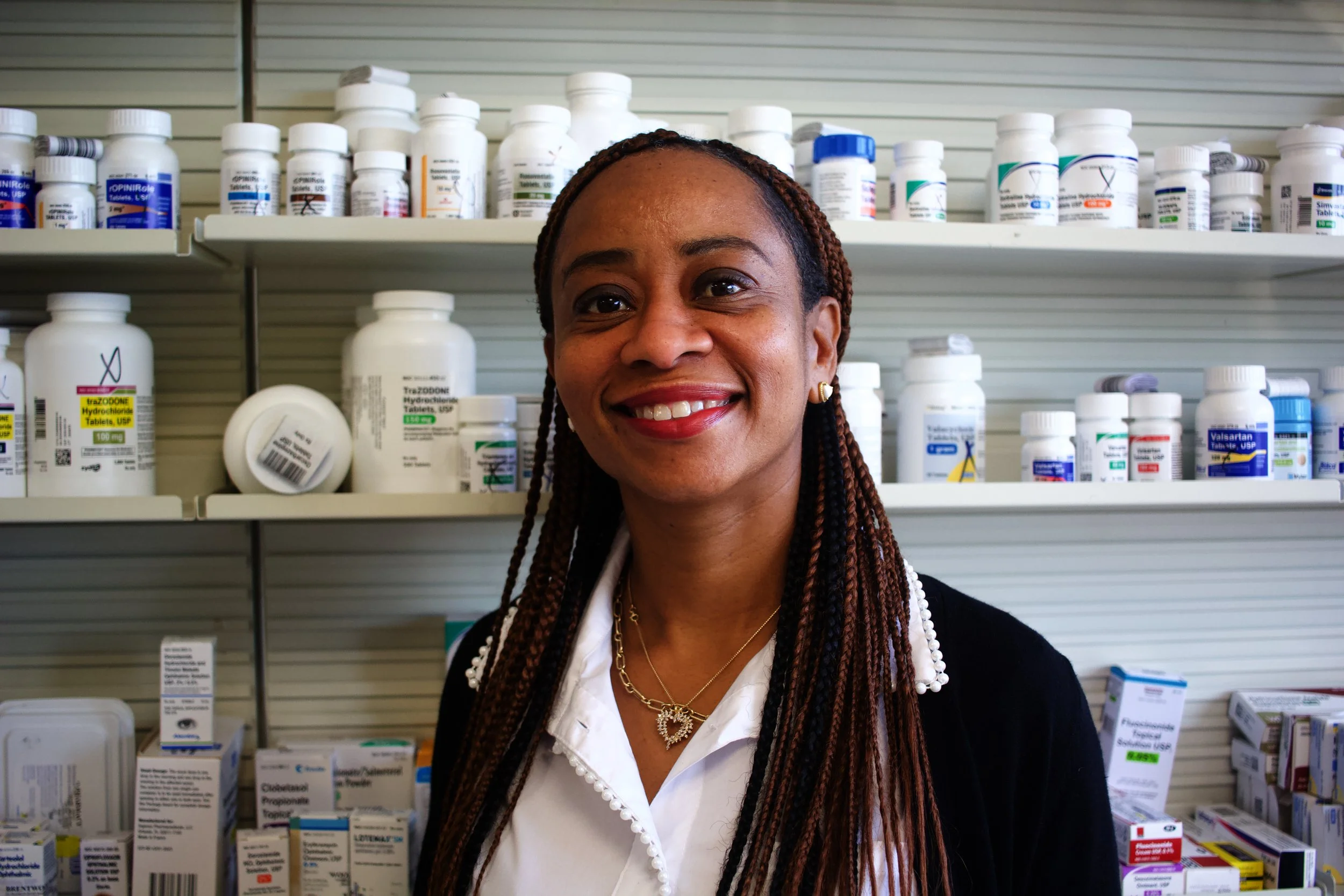 Silhouette of a dog on a leash in a grassy outdoor area at sunset.