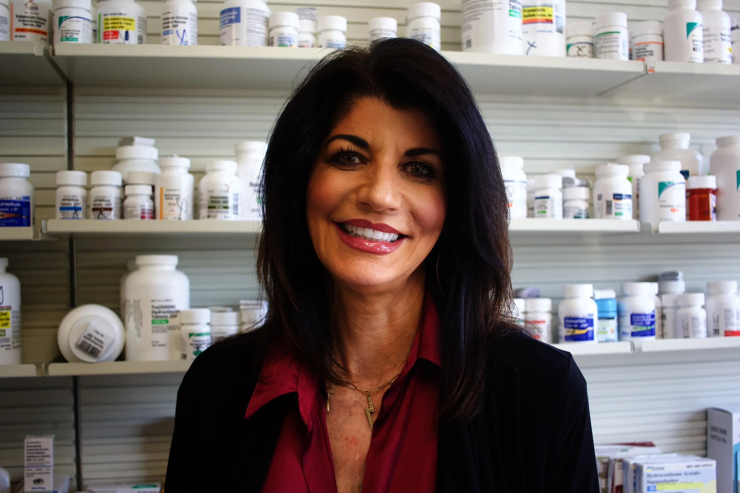 Silhouette of a woman with long hair in front of a sunset background on a beach.