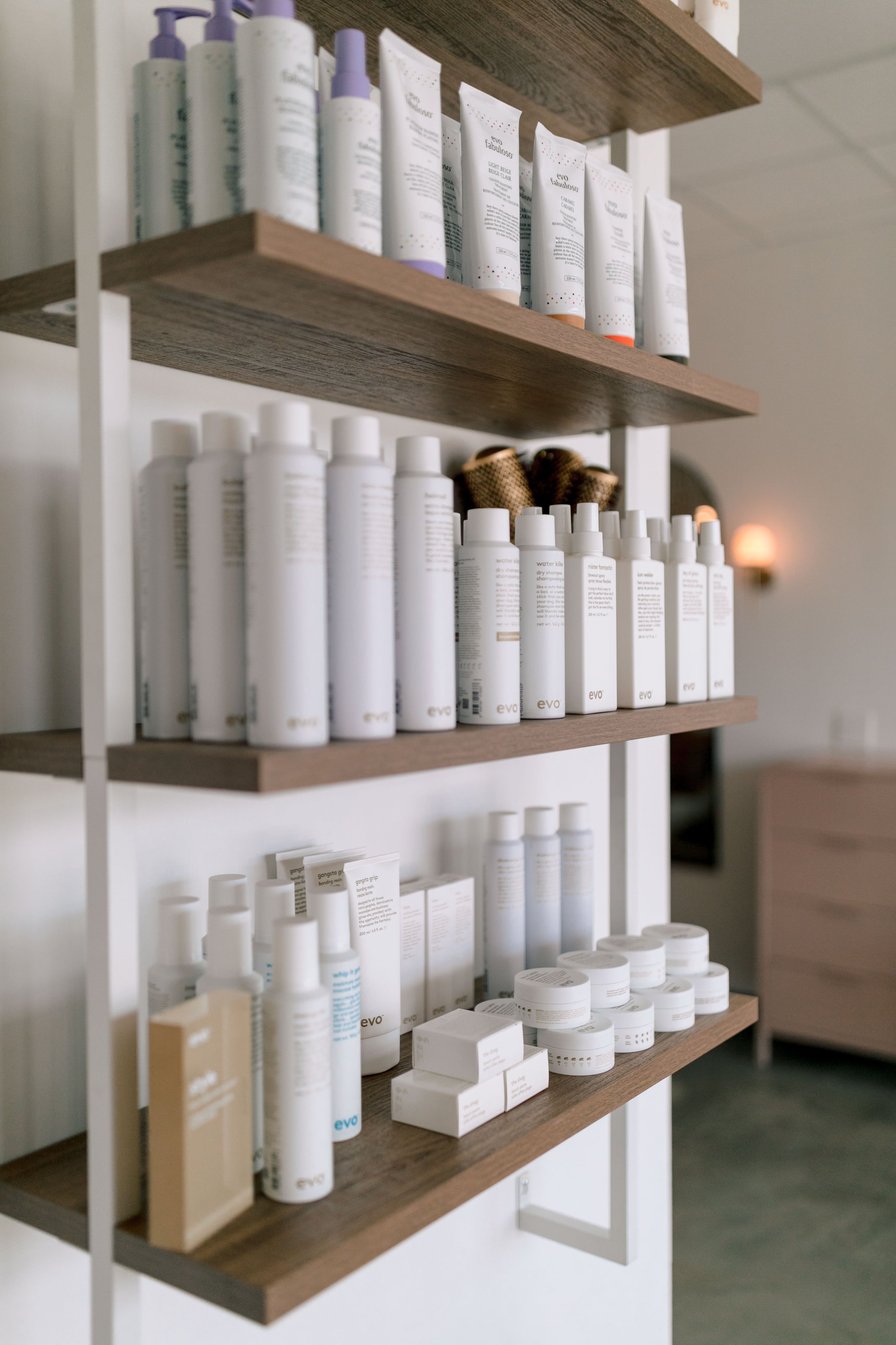 Shelves filled with white skincare and cosmetic products in a spa or beauty salon.