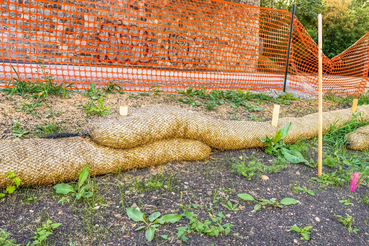Biodegradable erosion control straw sock guard fixed on construction slope to protect from water runoff erosion