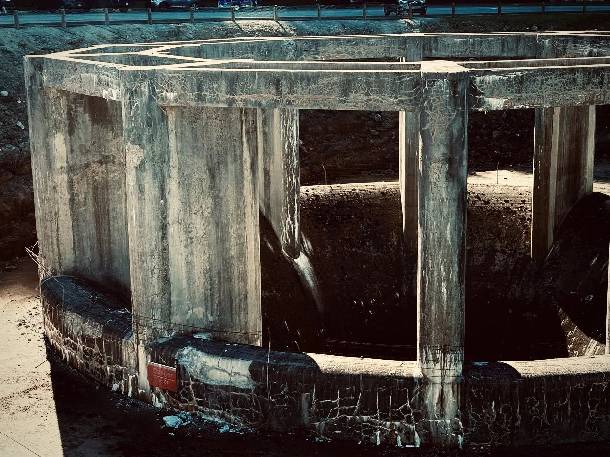 An empty reservoir or water storage tank with a concrete structure in a construction or industrial site.