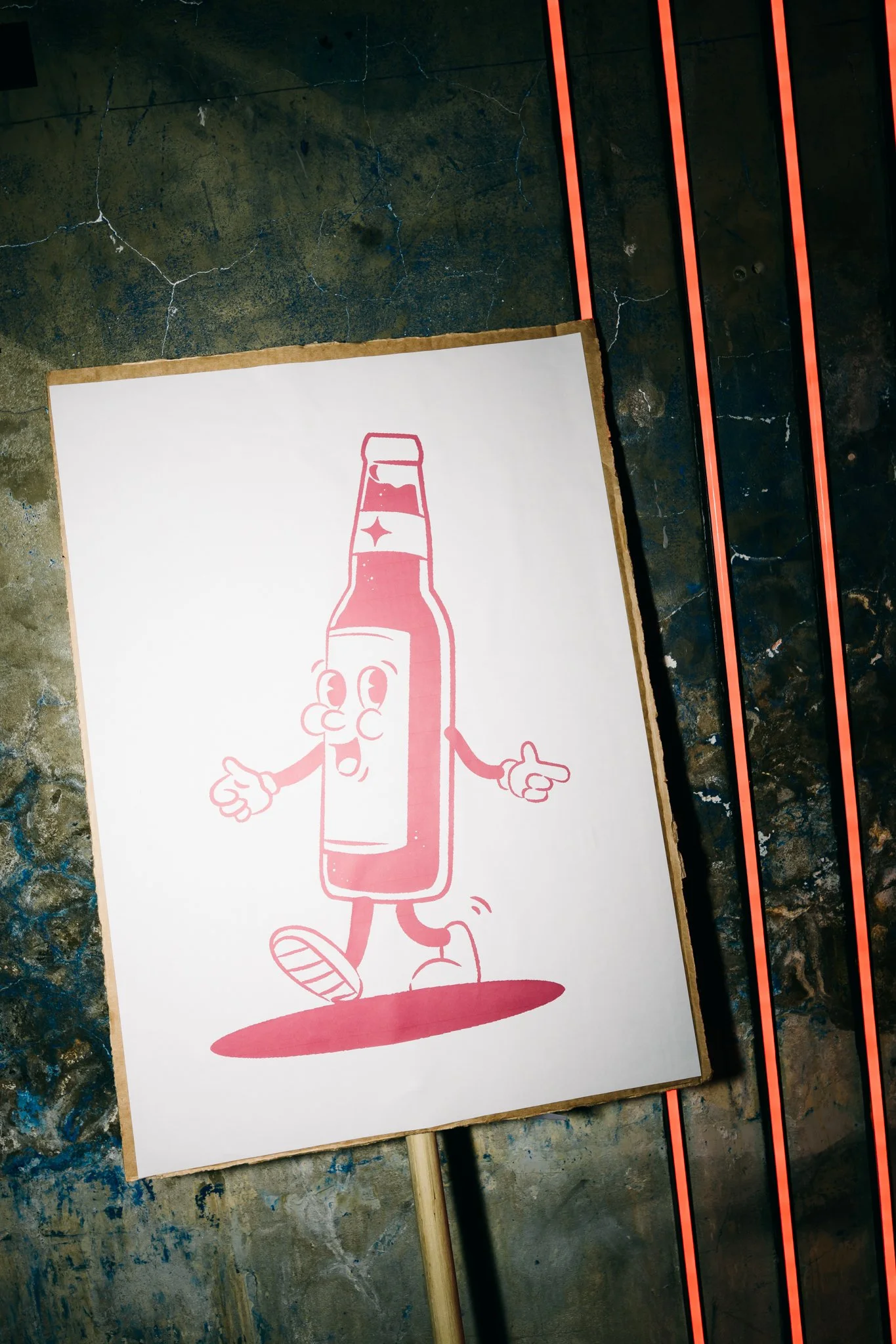 A cartoon illustration of a smiling, anthropomorphic soda bottle with arms, legs, and a face, standing on a shadow. The soda bottle has a star on its chest, and it appears to be in a playful, walking pose.