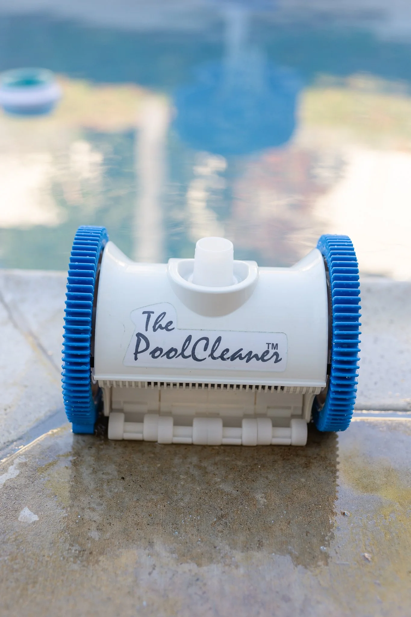 A Pool Vacuum Cleaner with brand new, clean wheels on a pool deck.