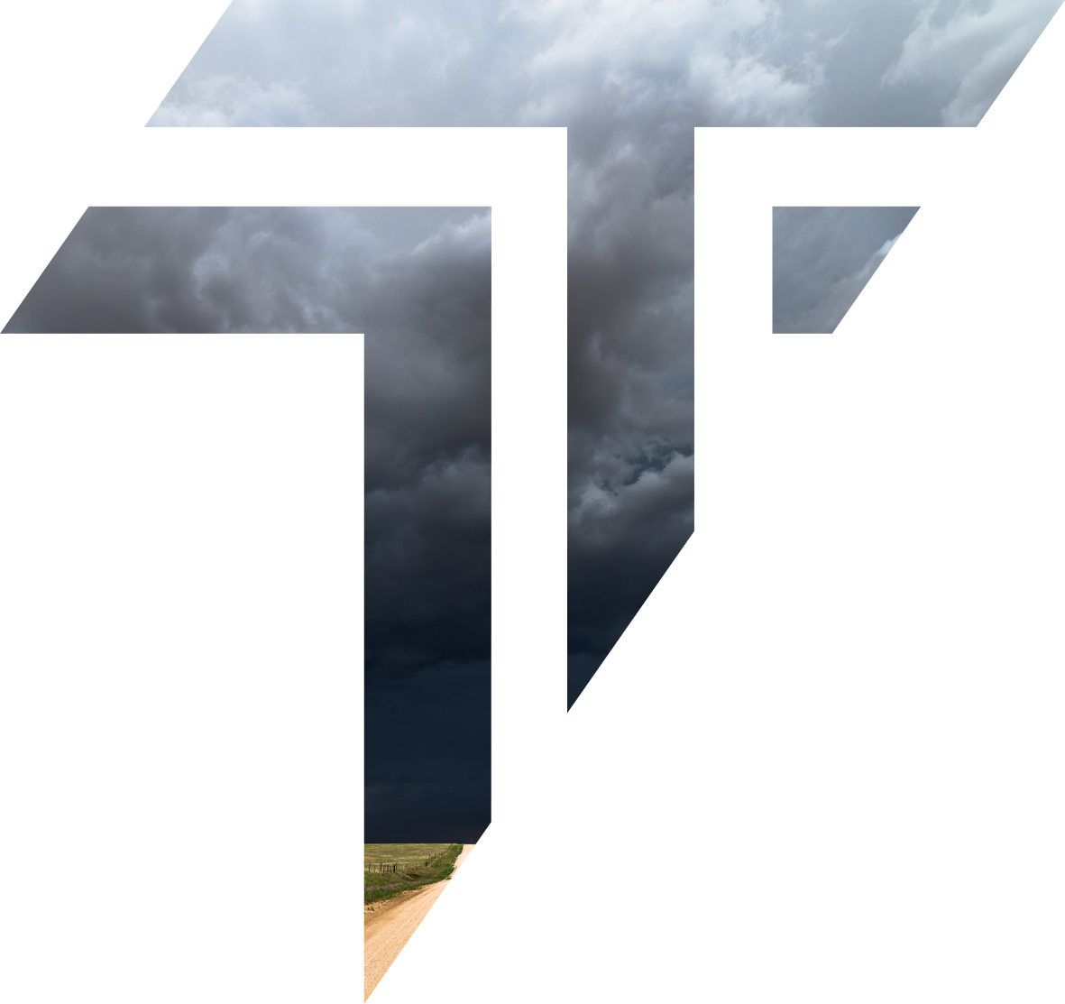 Storm clouds covering the sky over a rural dirt road in an open field.