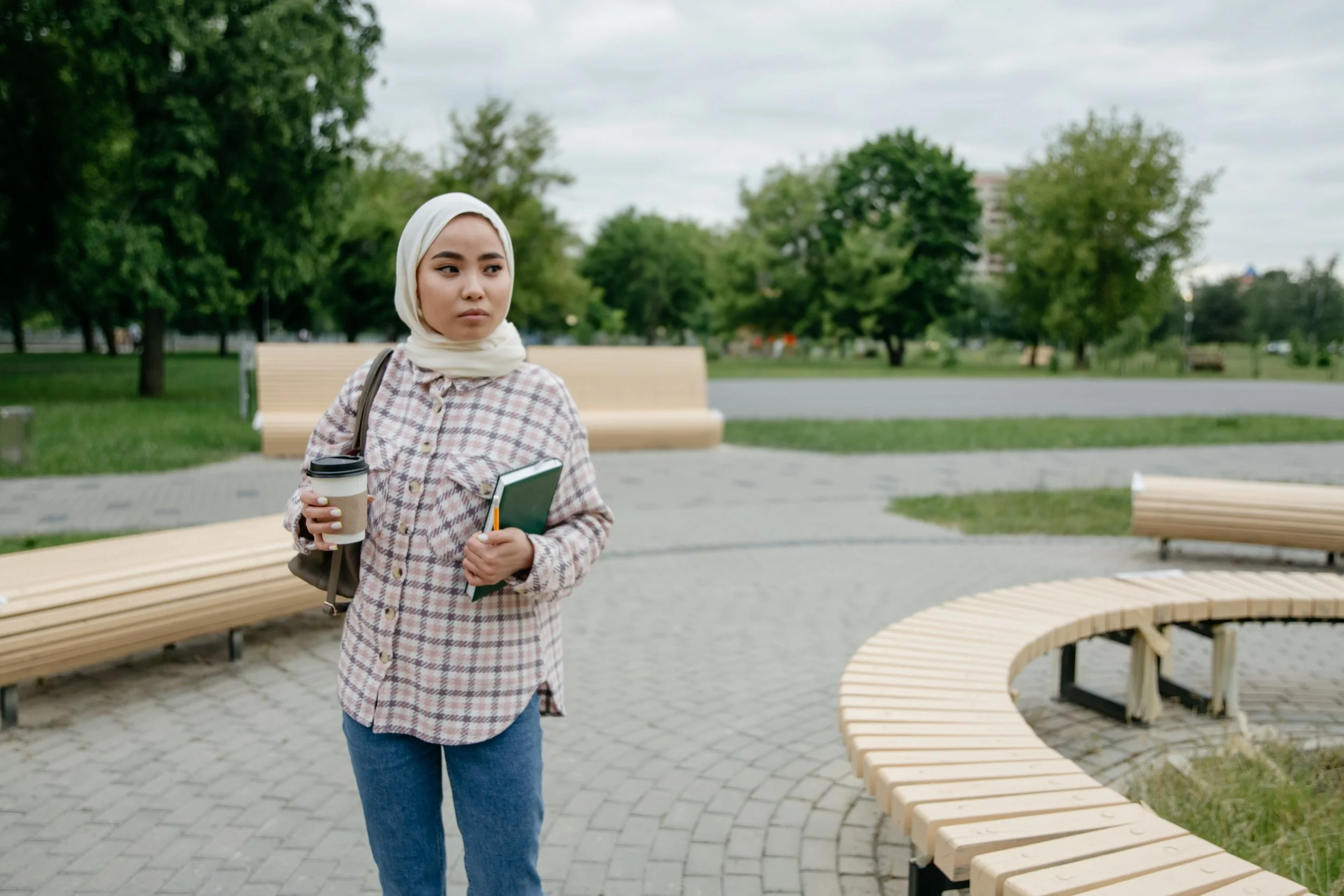 college student wearing hijab and holding a cup of drink