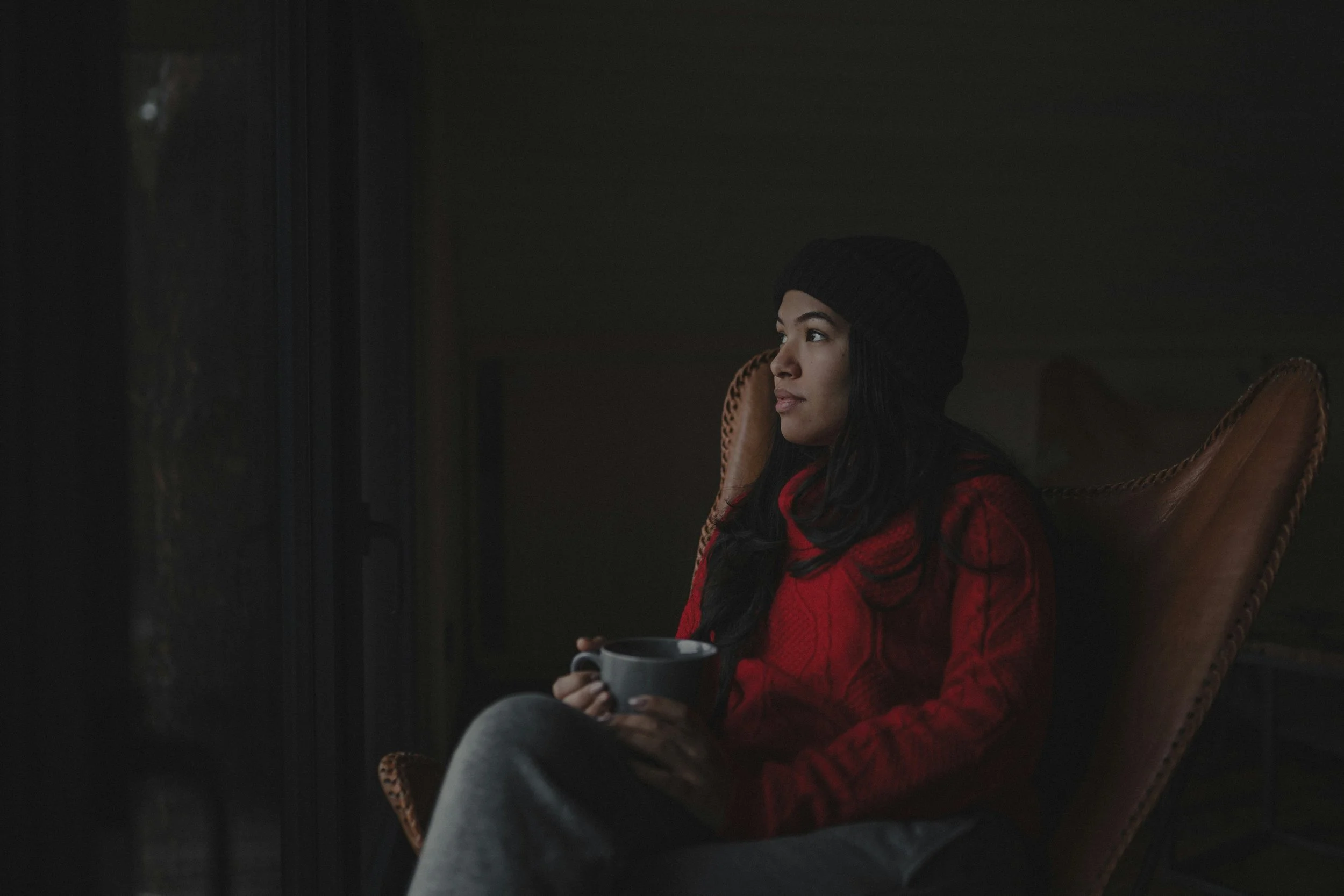 A Muslim adult sitting quietly, looking reflective